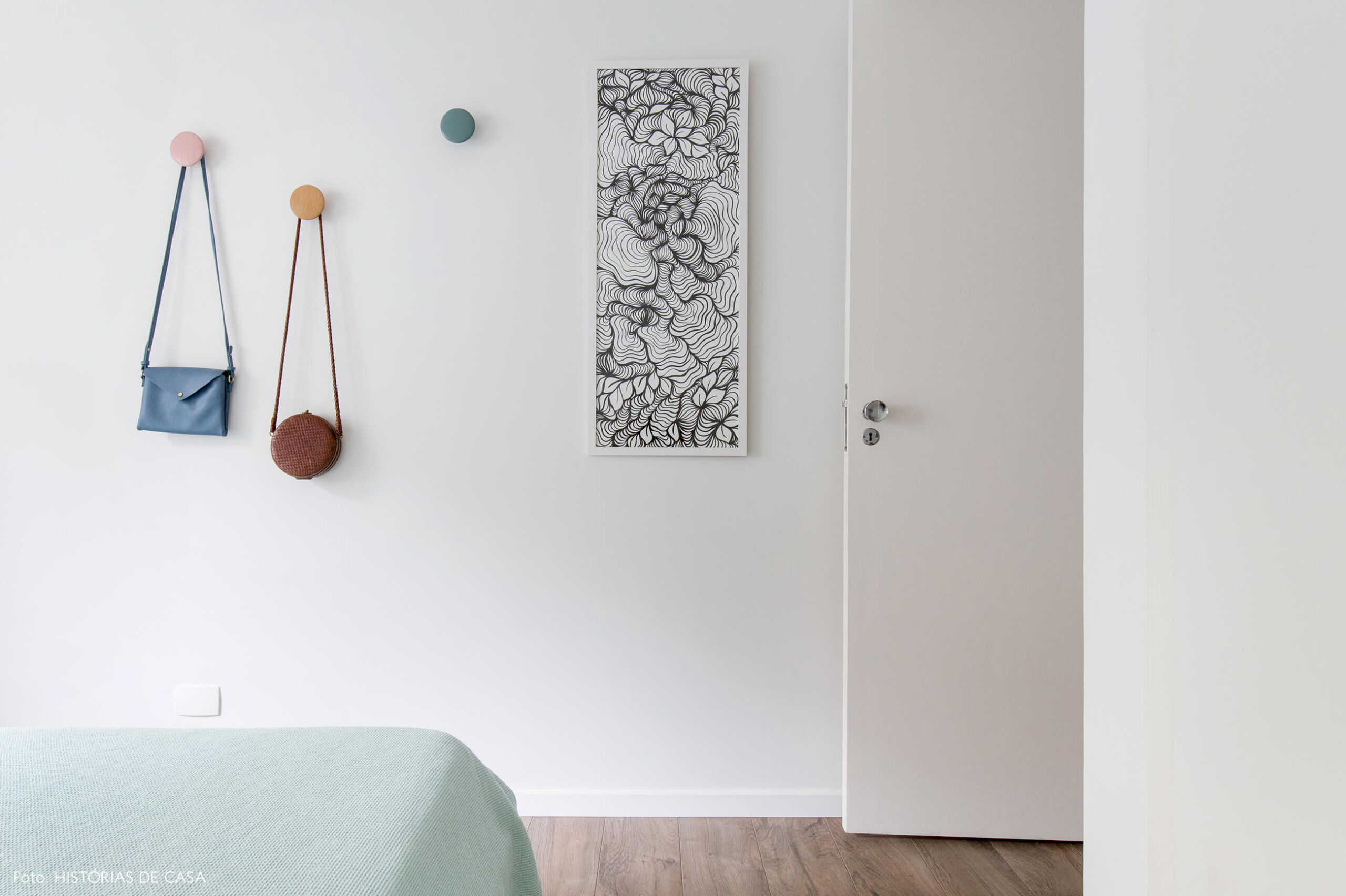 Quarto com tons neutros e ganchos de parede coloridos