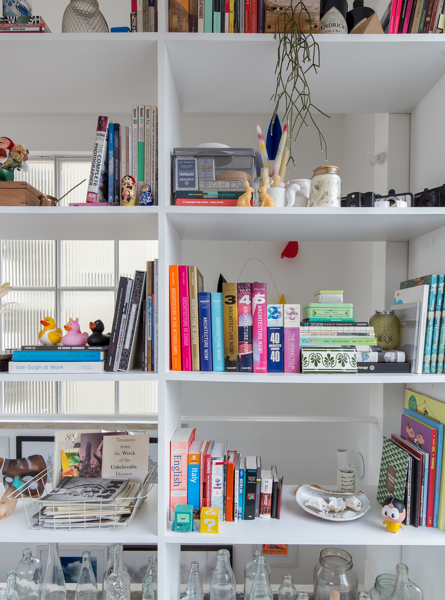 Estante branca vazada com decoração colorida e objetos de coleção