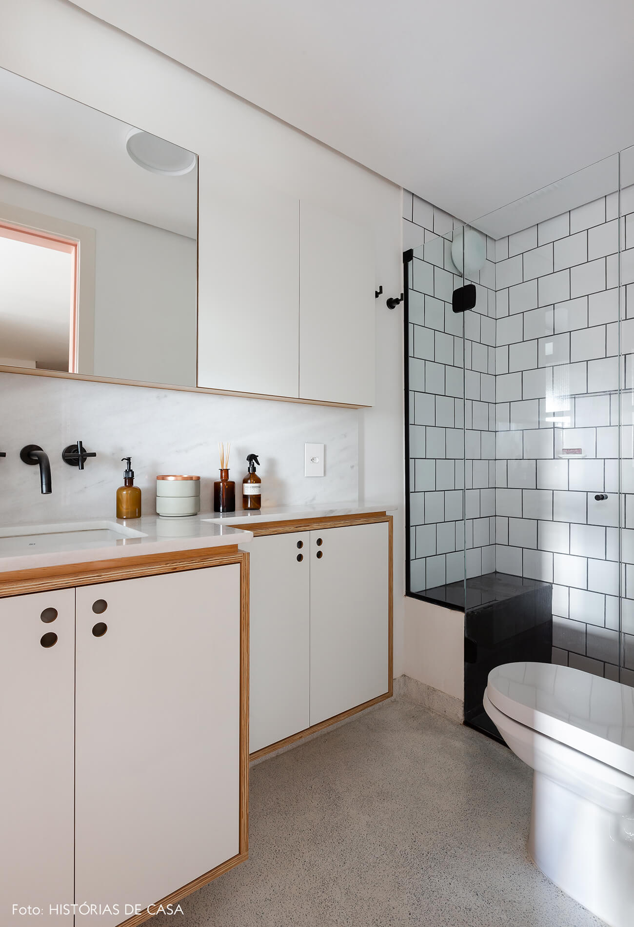 Banheiro em apartamento pequeno com revestimentos brancos