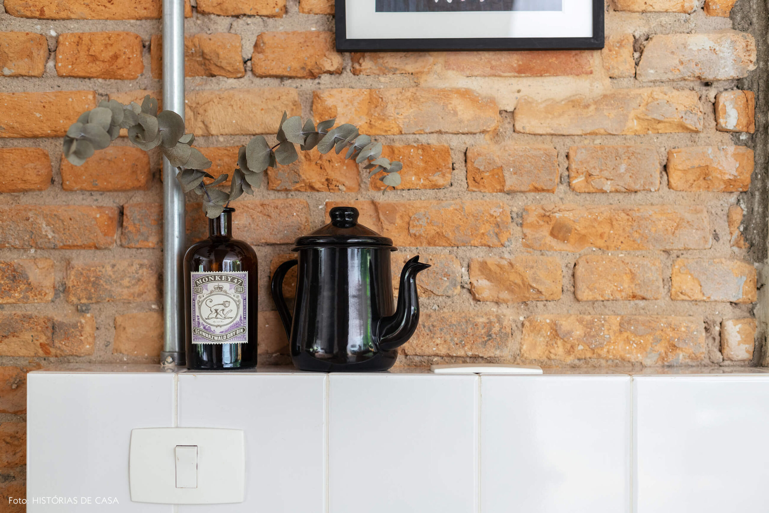Parede de tijolinho com frontão de azulejos na cozinha