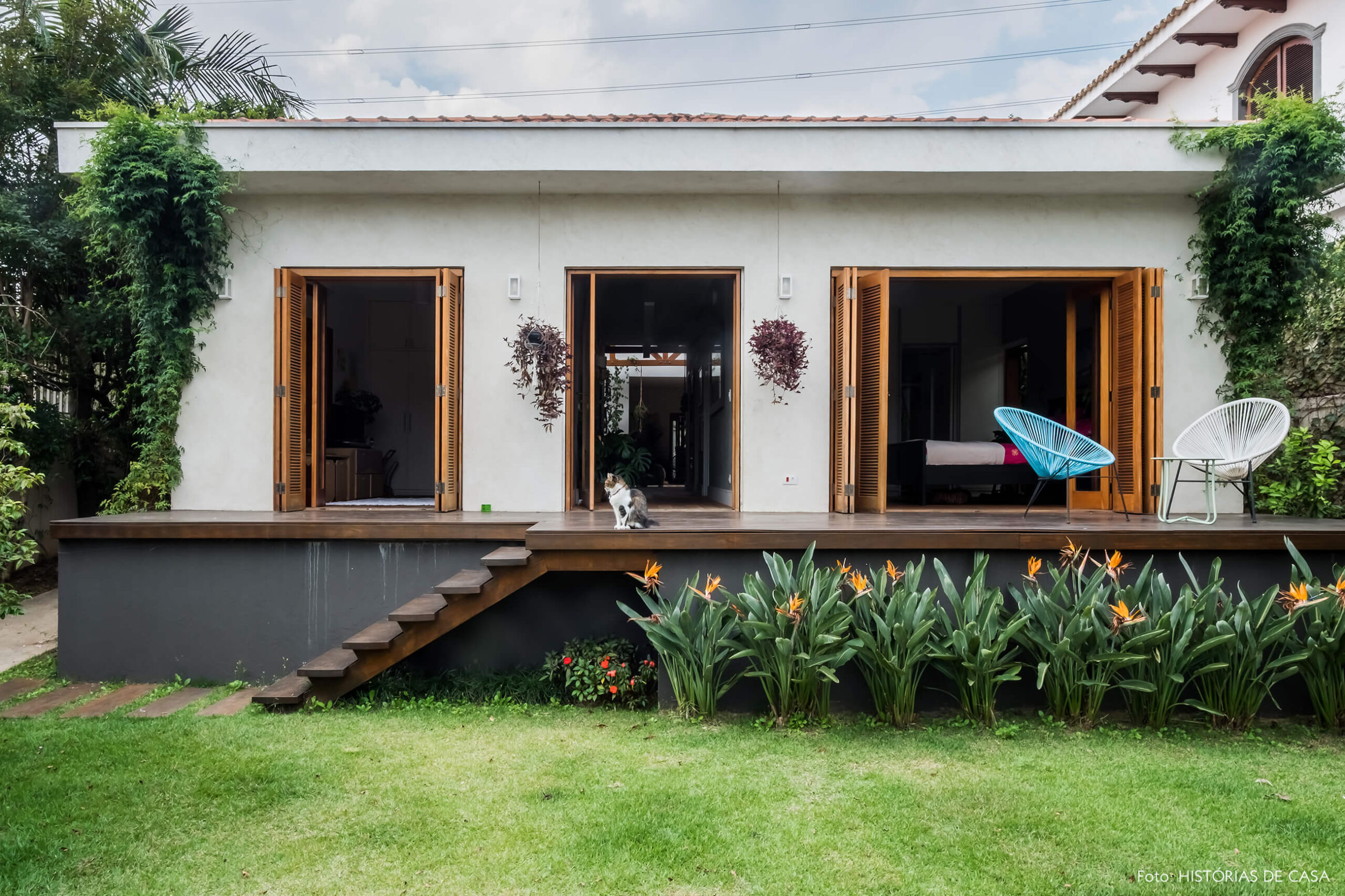 Casa com jardim nos fundos. Gramado, deck e rede de balanço.