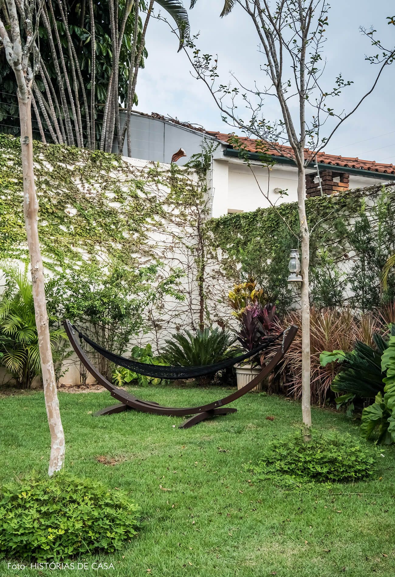 Casa com jardim nos fundos. Gramado, deck e rede de balanço.