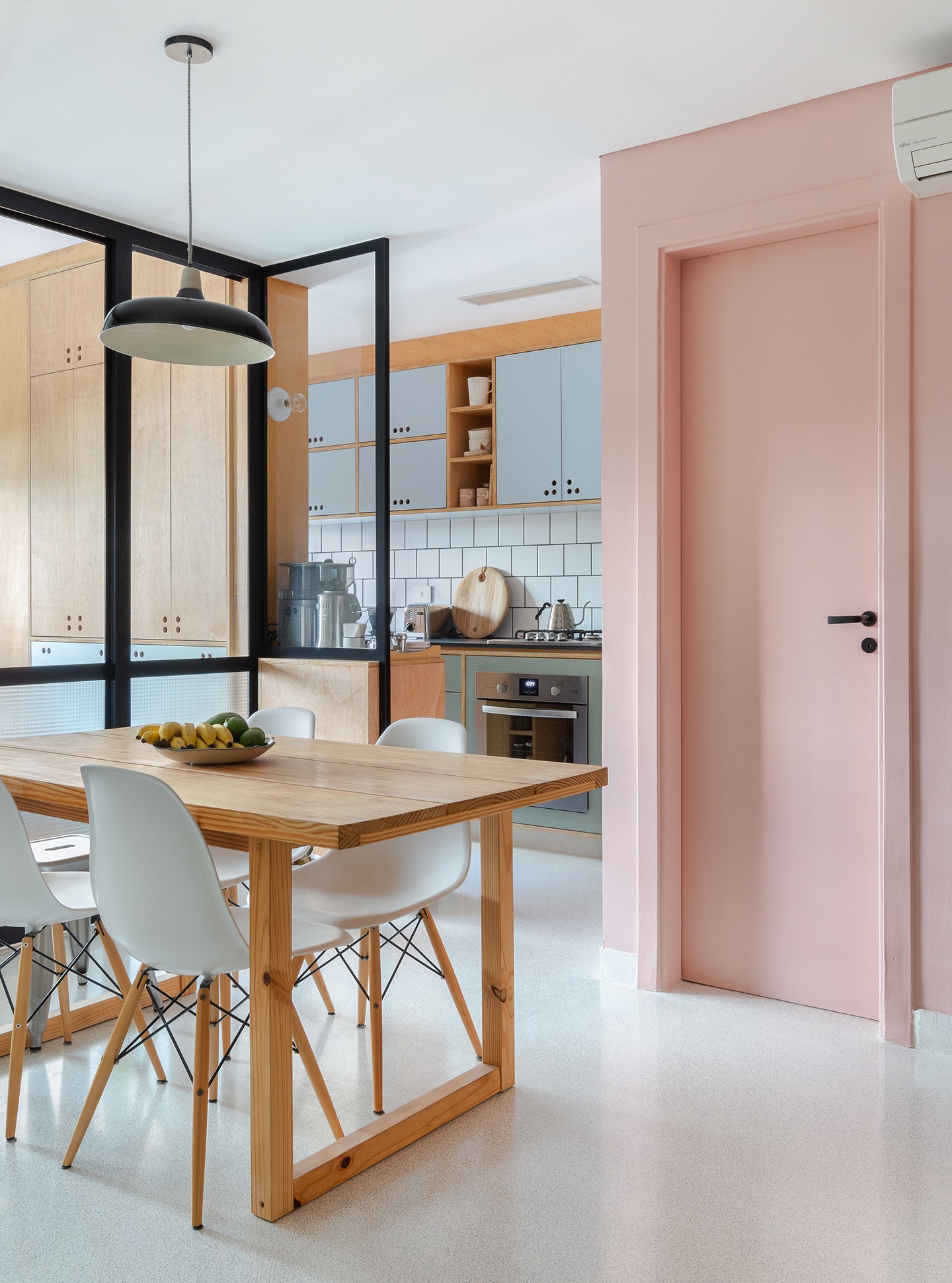 Apartamento pequeno com tons claros e parede rosa, ambientes integrados