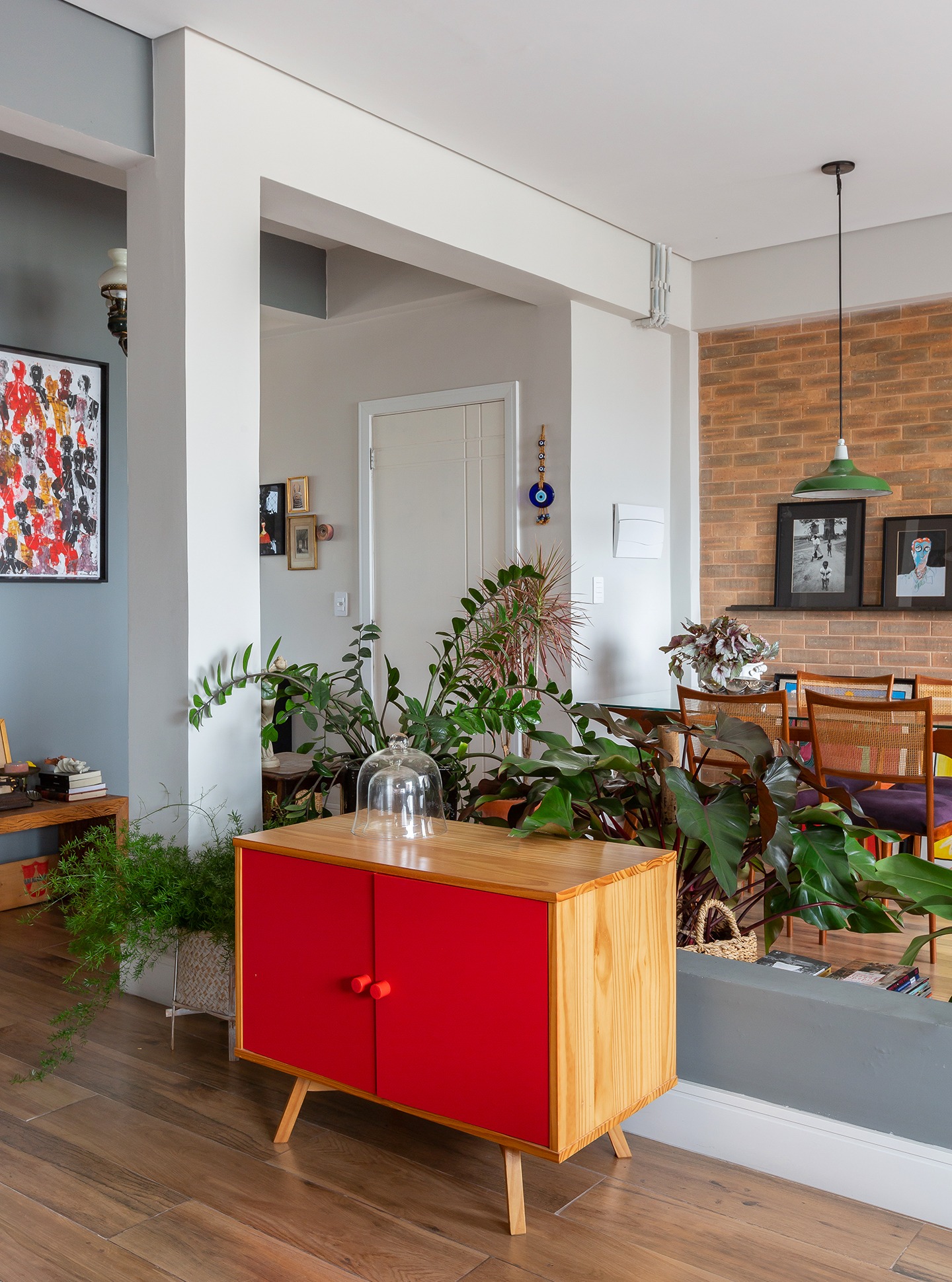 Apartamento pequeno com divisória de plantas e móvel colorido