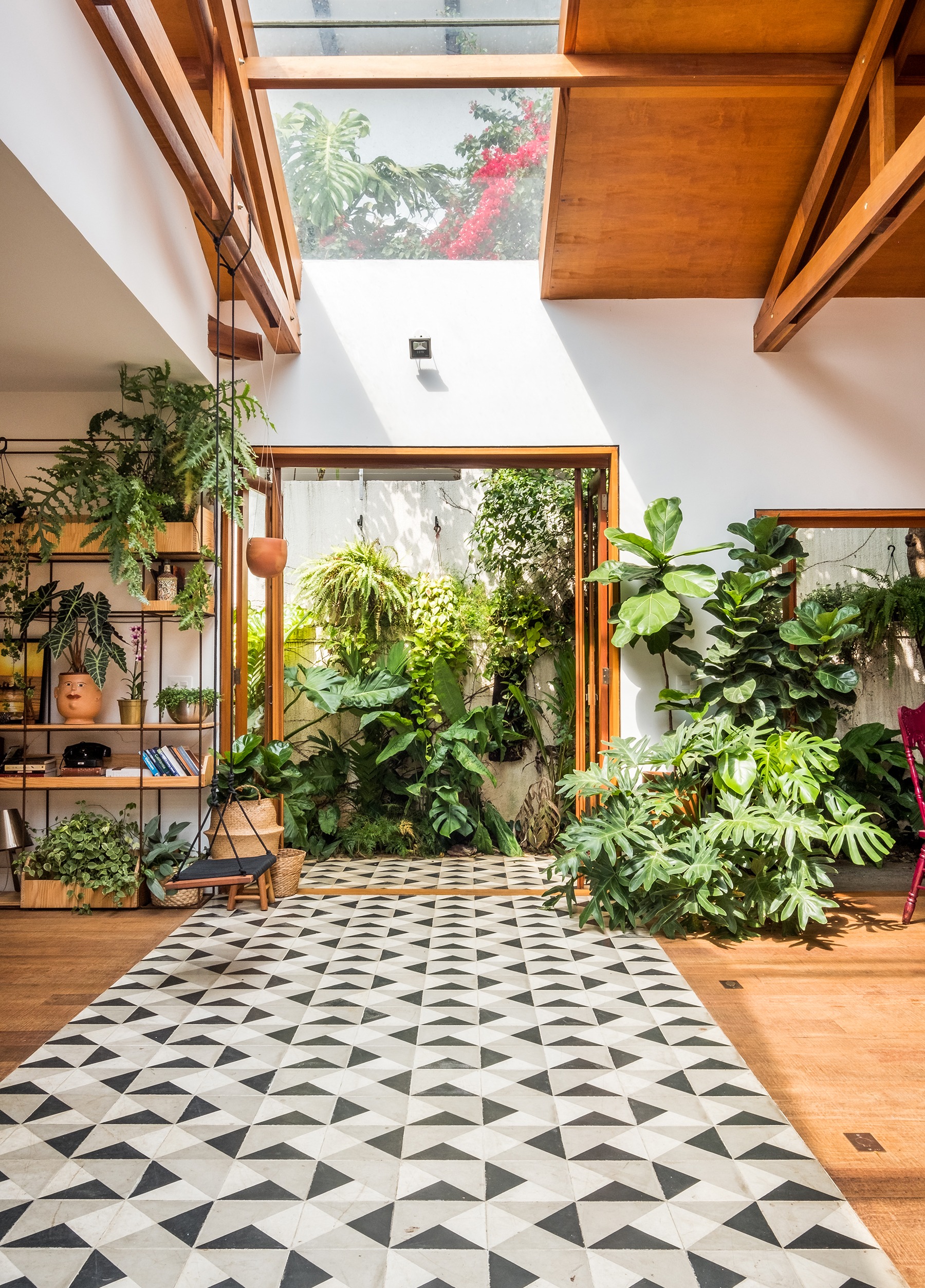 Casa térrea com forro de madeira, espaços abertos e muitas plantas