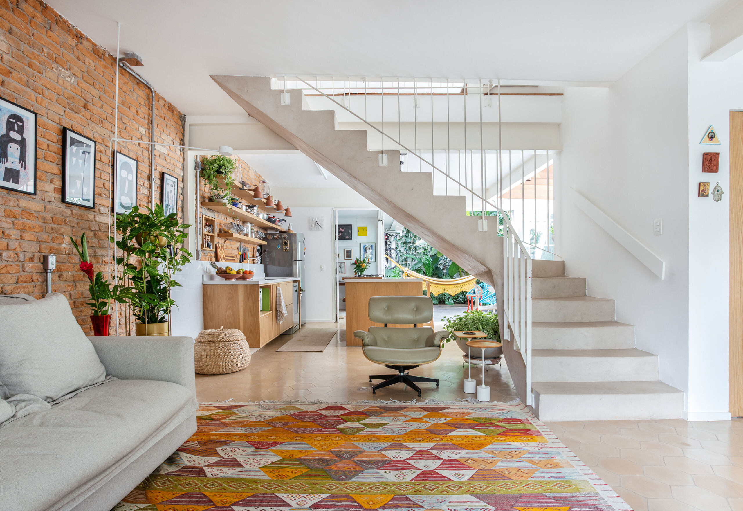 Sala integrada com escada no centro e tapete colorido