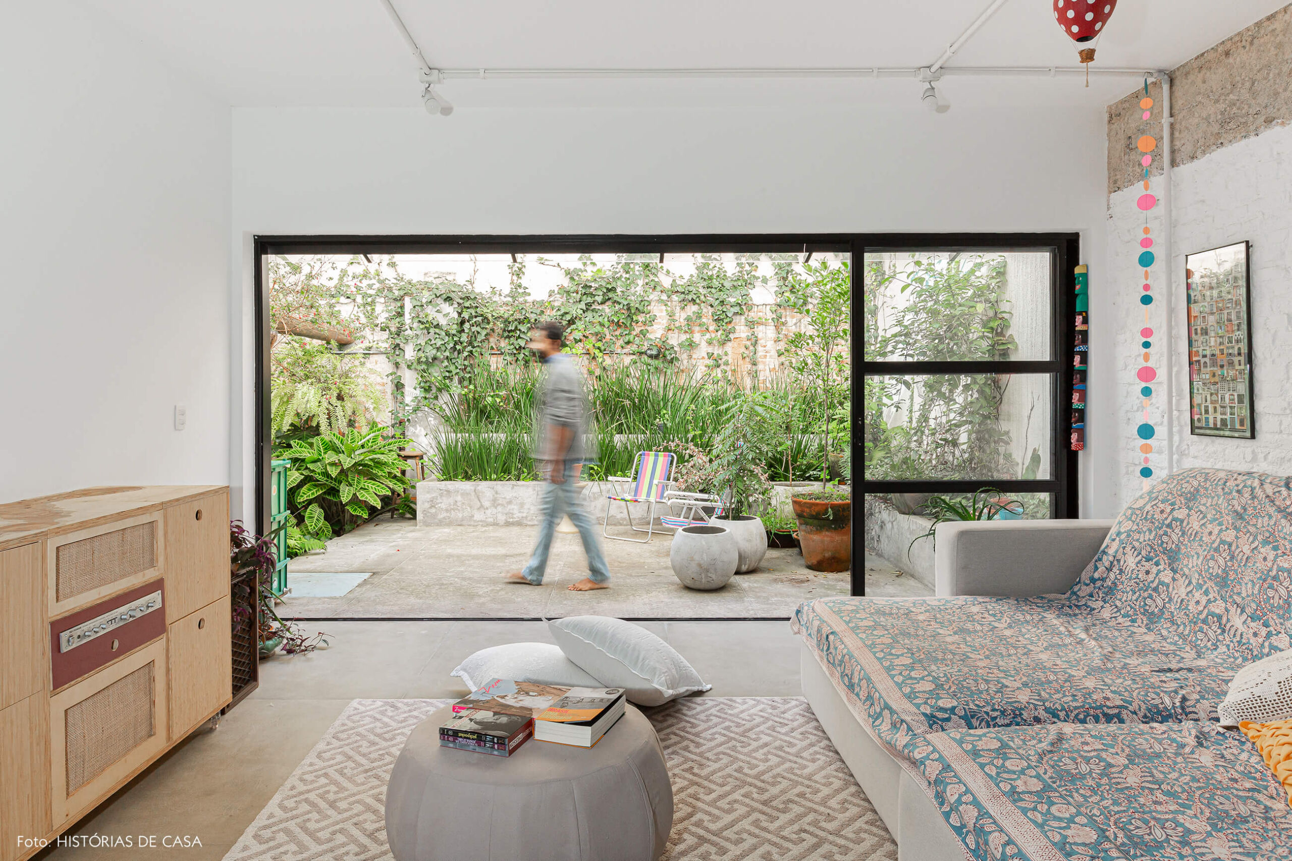 Apartamento térreo, sala integrada ao jardim e parede de tijolinhos brancos