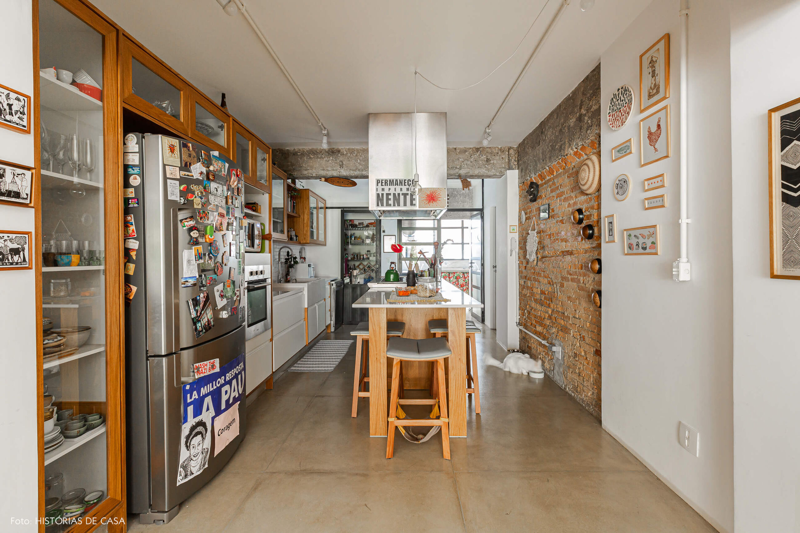 Apartamento térreo, cozinha com paredes de tijolinho e bancada central