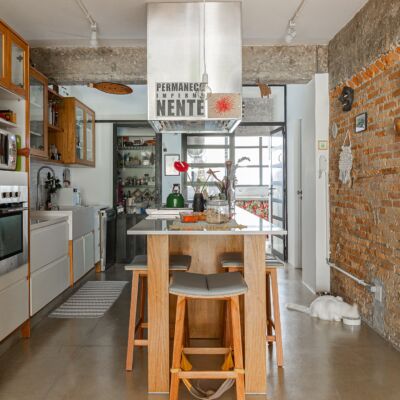Apartamento térreo, cozinha com paredes de tijolinho e bancada central