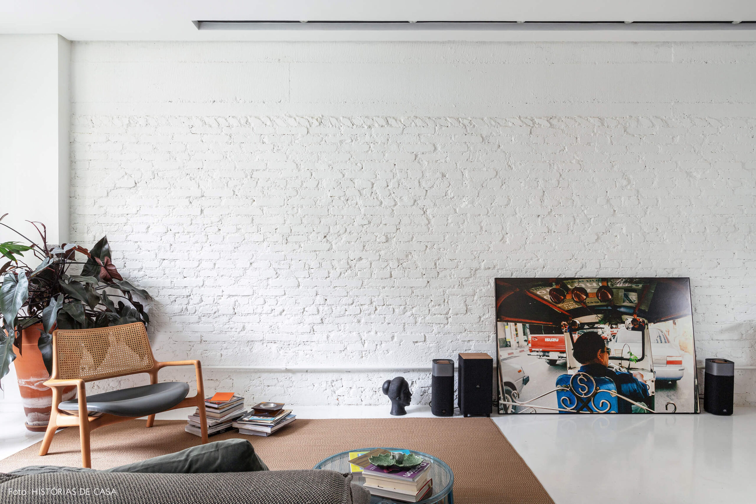 Apartamento escandinavo, sala com parede de tijolinho branco e plantas