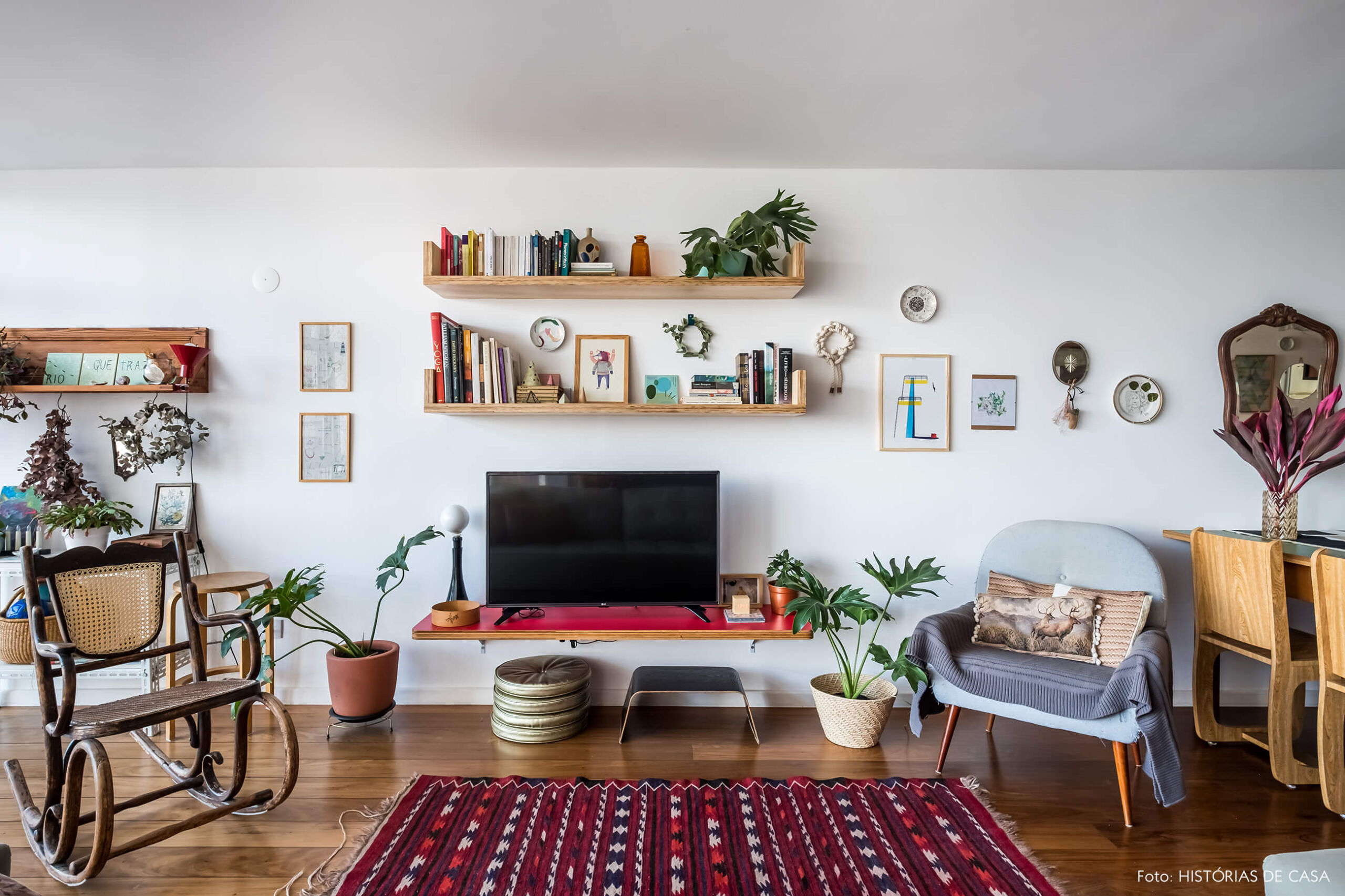 Sala com prateleiras na parede da TV