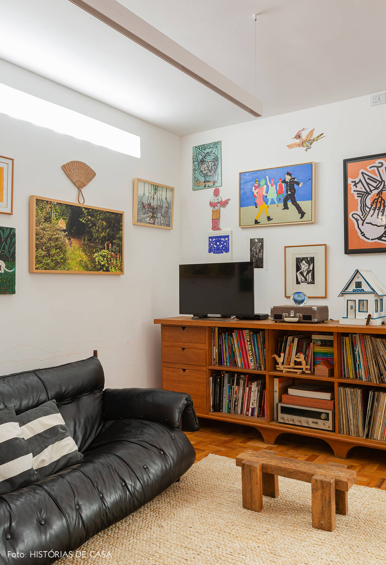 Apartamento reformado, sala com parede de quadros e detalhes coloridos