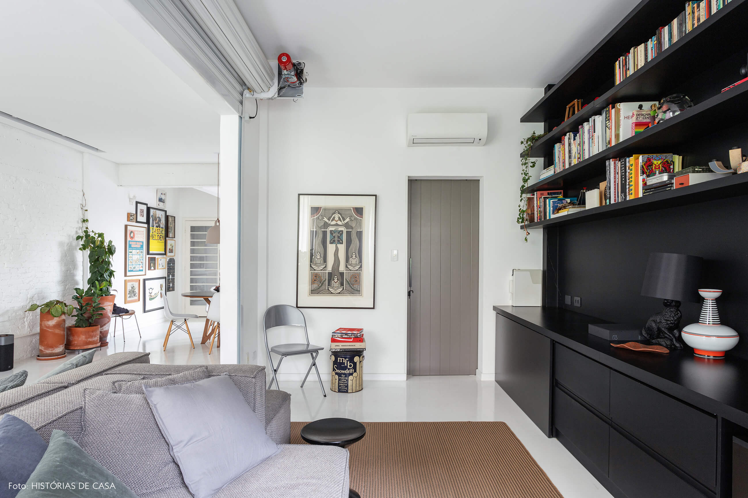Apartamento escandinavo, sala com parede de tijolinho branco e marcenaria preta