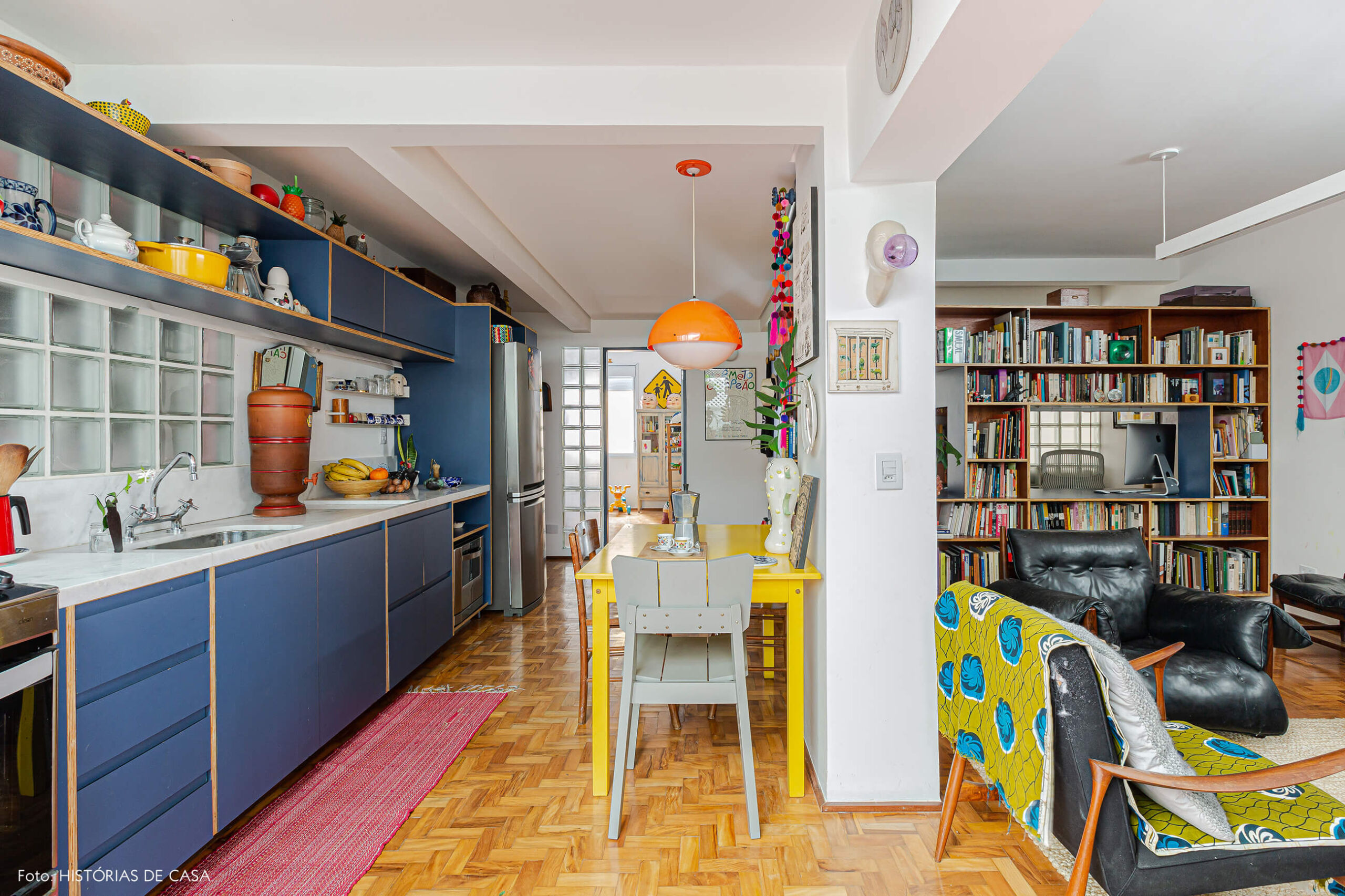 Apartamento reformado, cozinha colorida integrada com mesa amarela
