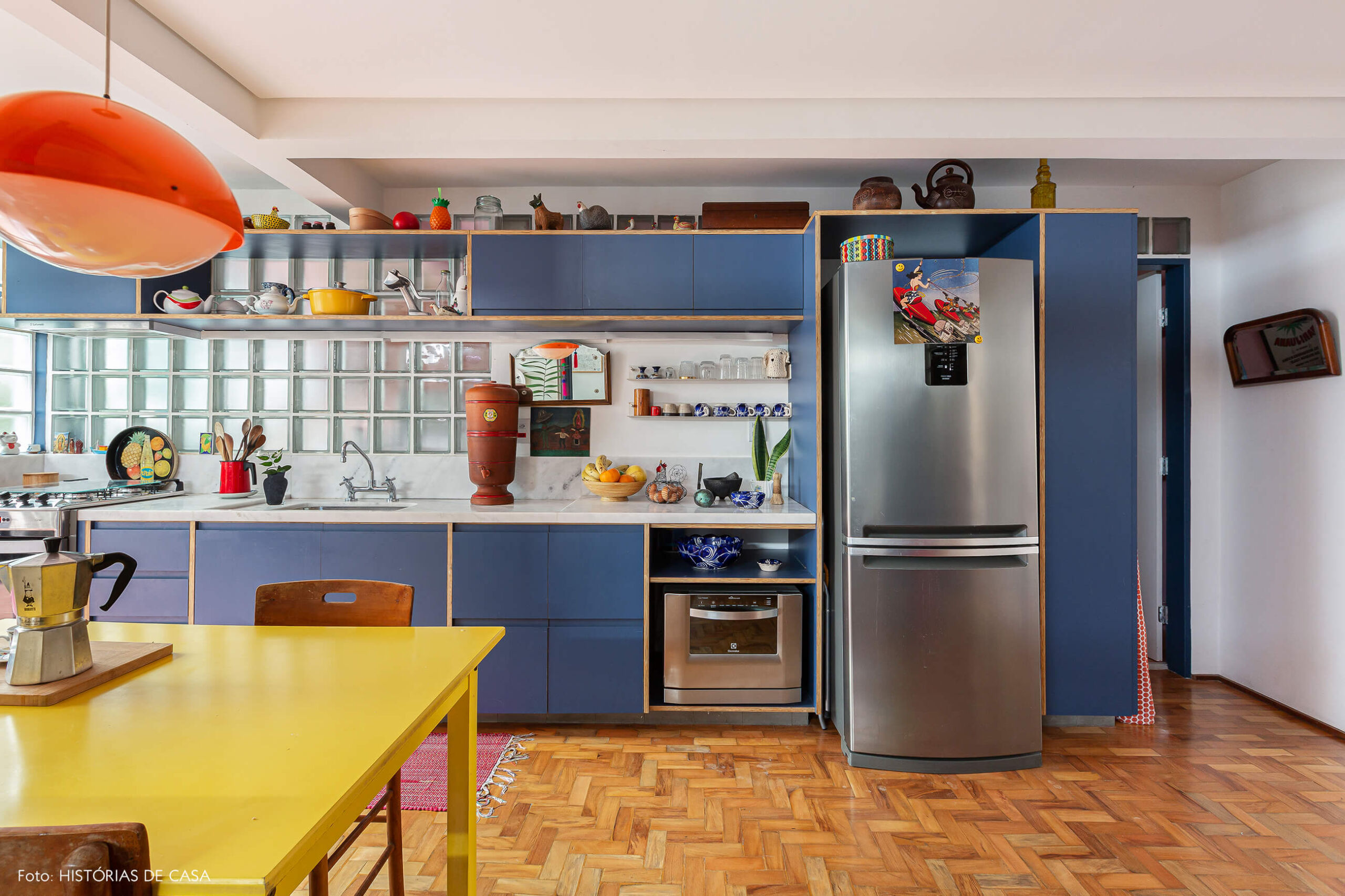 Apartamento reformado, cozinha com armários azuis e mesa amarela