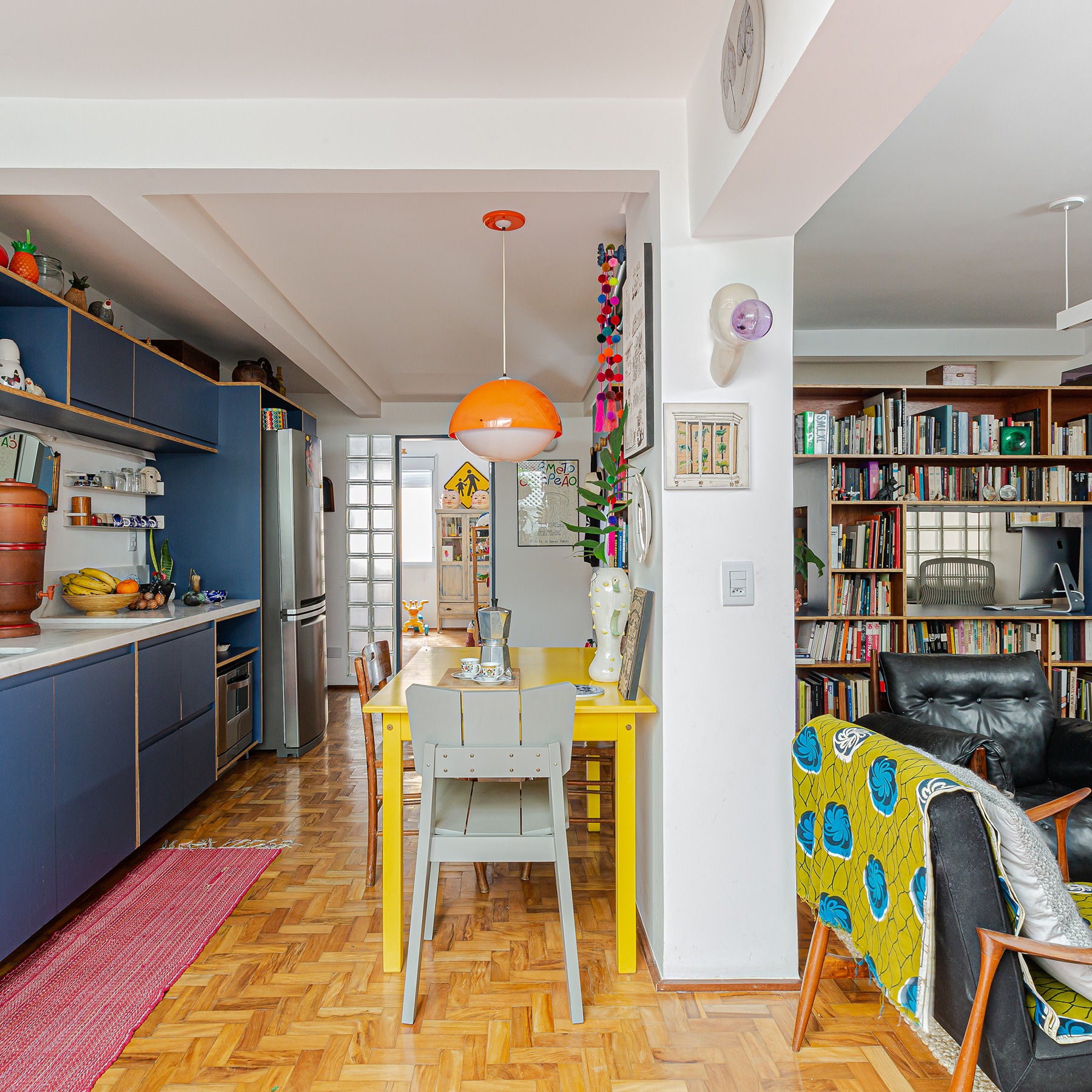 Apartamento reformado, cozinha colorida integrada com mesa amarela
