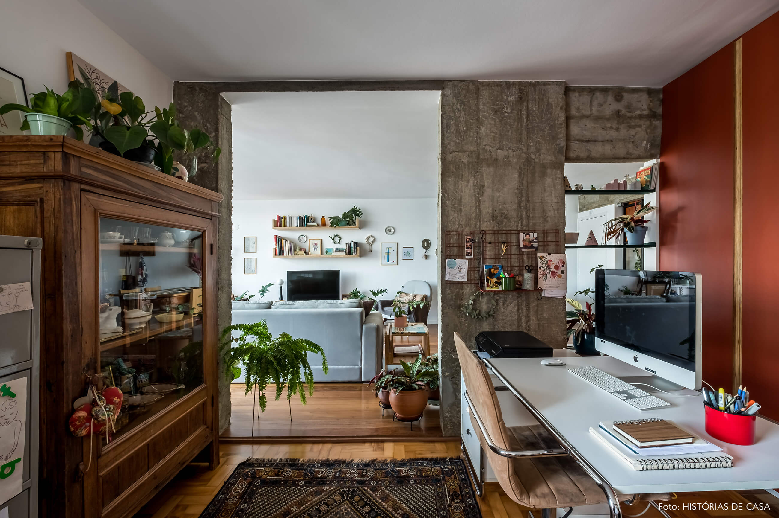 Home office integrado com a sala, coluna de concreto e prateleiras