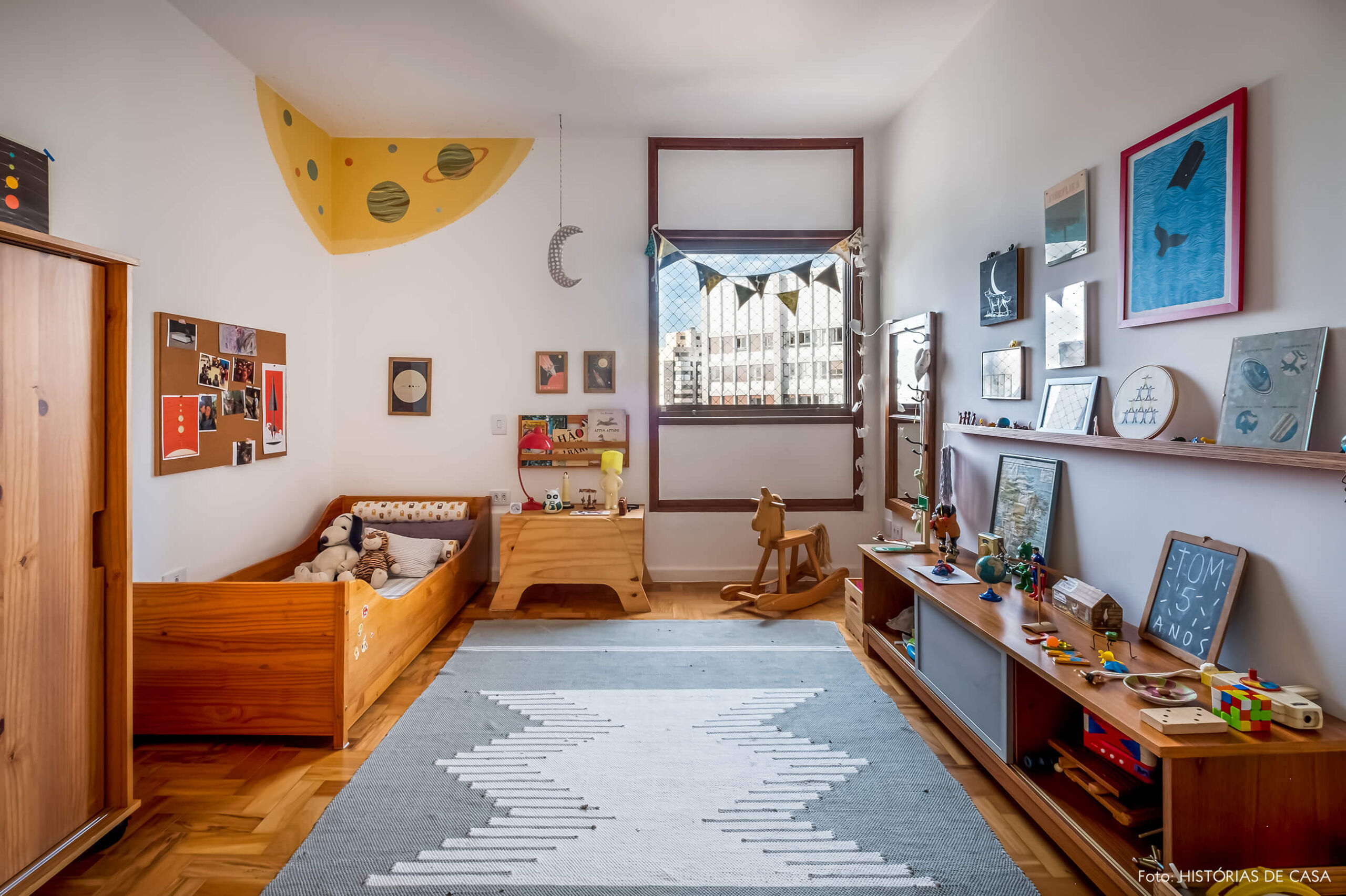 Quarto de criança com móveis de madeira e pintura na parede