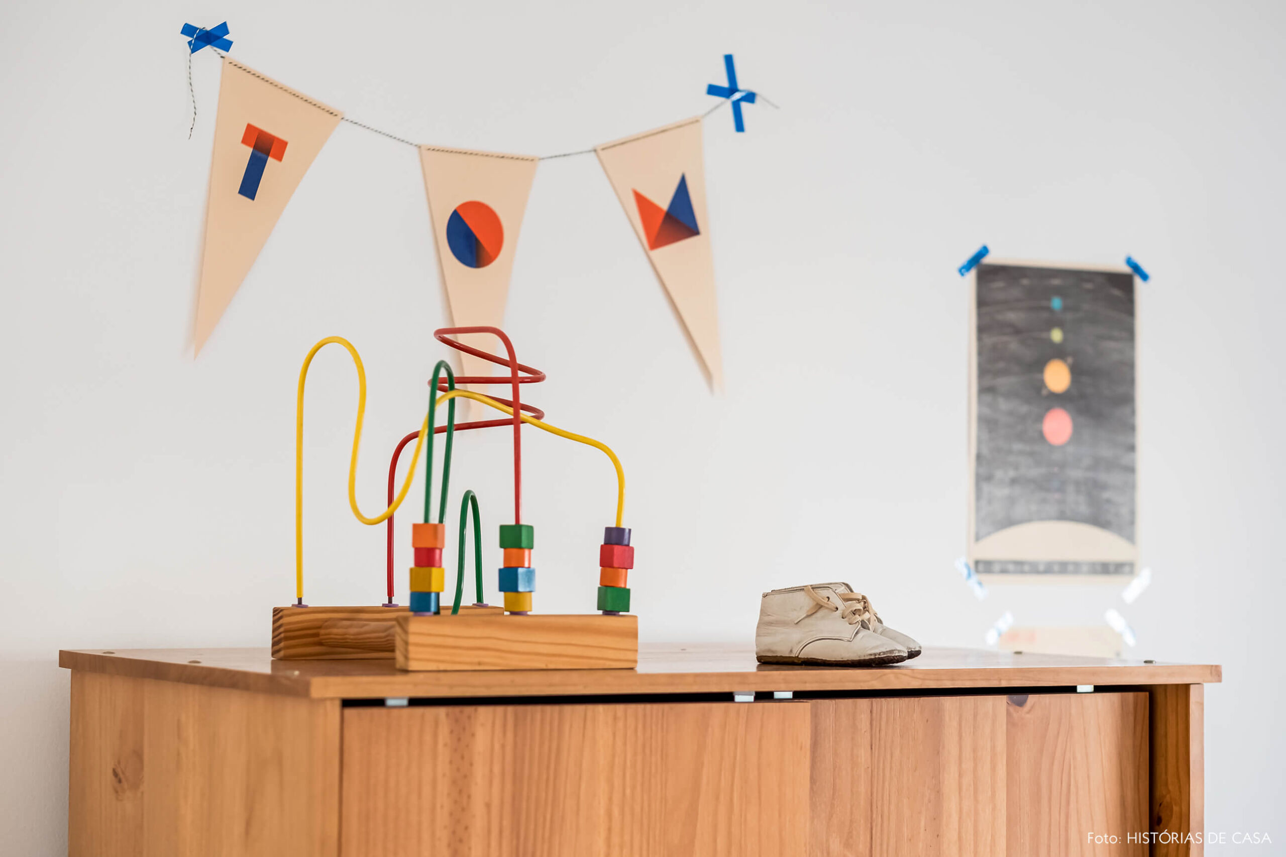 Quarto de criança com móveis de madeira e bandeirola