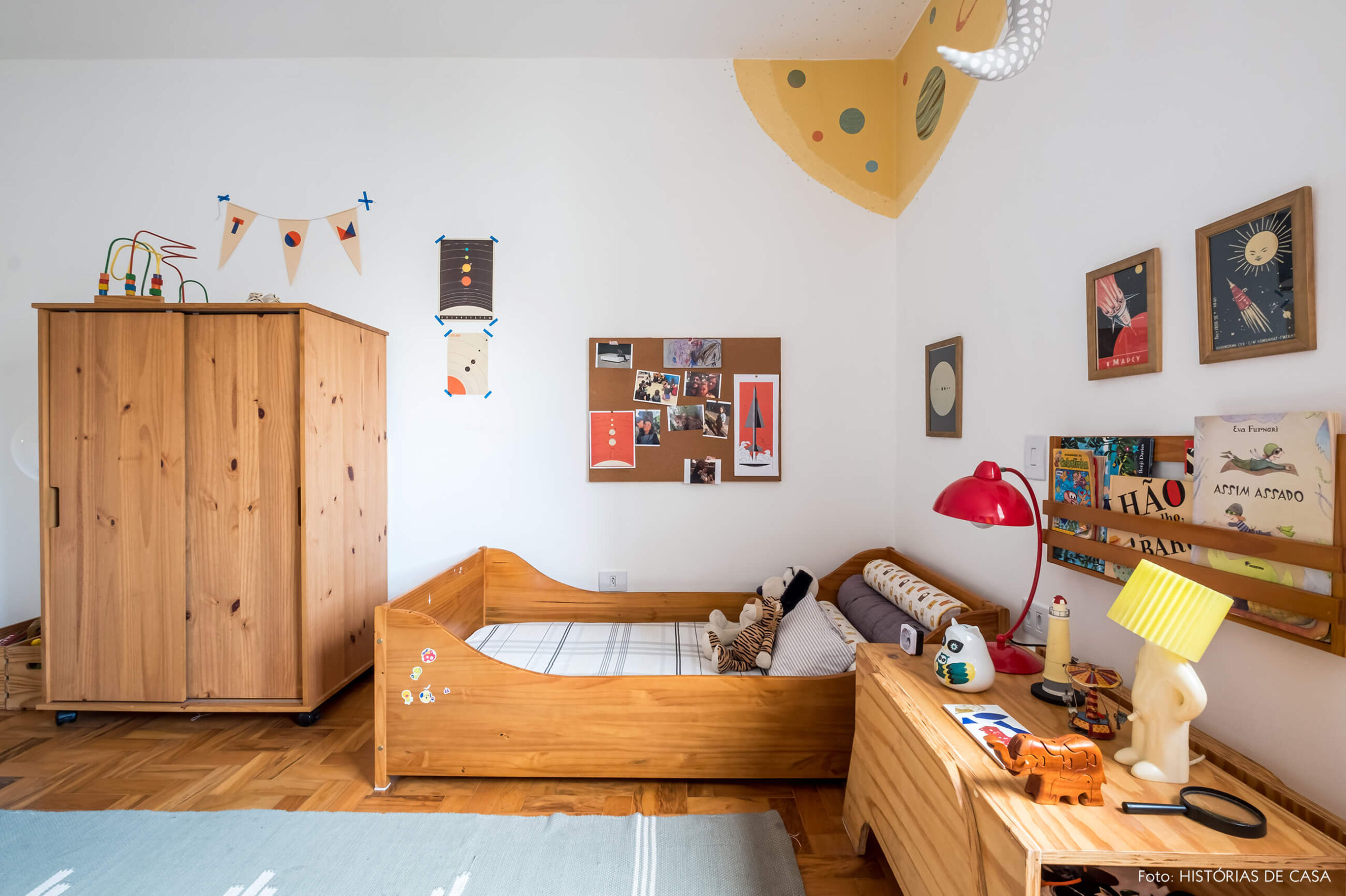 Quarto de criança com móveis de madeira e pintura na parede