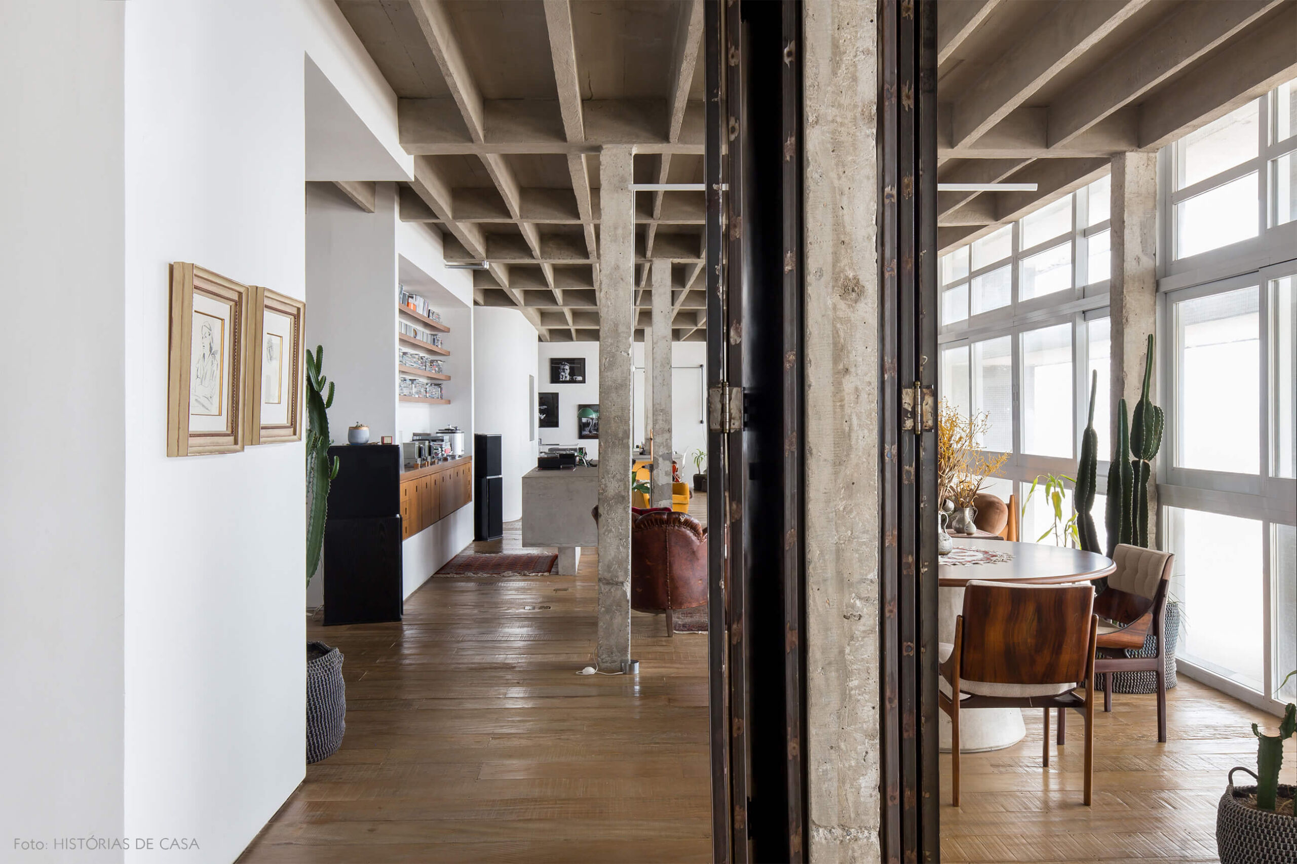 decoração colunas de concreto piso de madeira quadros e cadeira de madeira