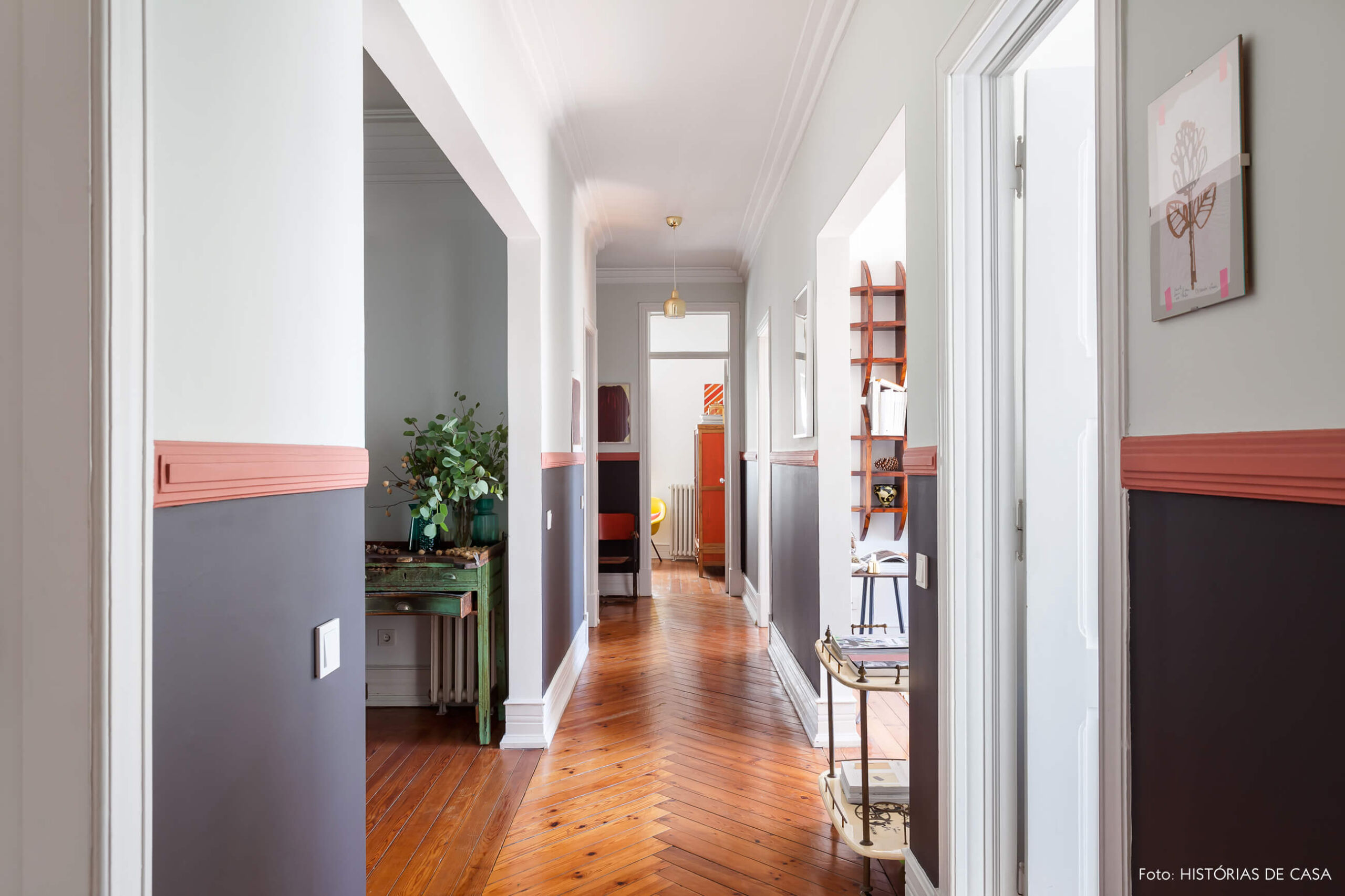 Decoração corredor meia parede preta e piso de madeira