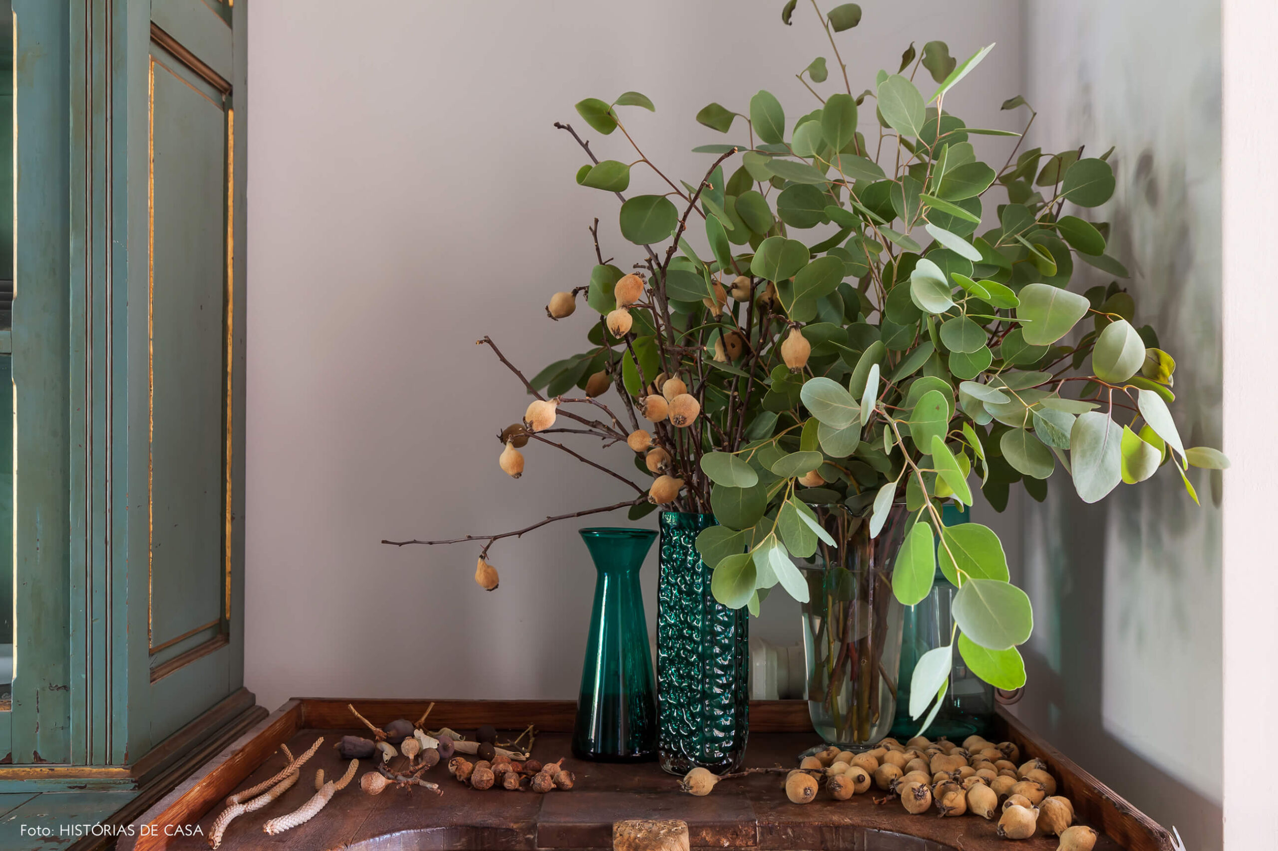 Detalhe da decoração com armário e vasos verdes e plantas