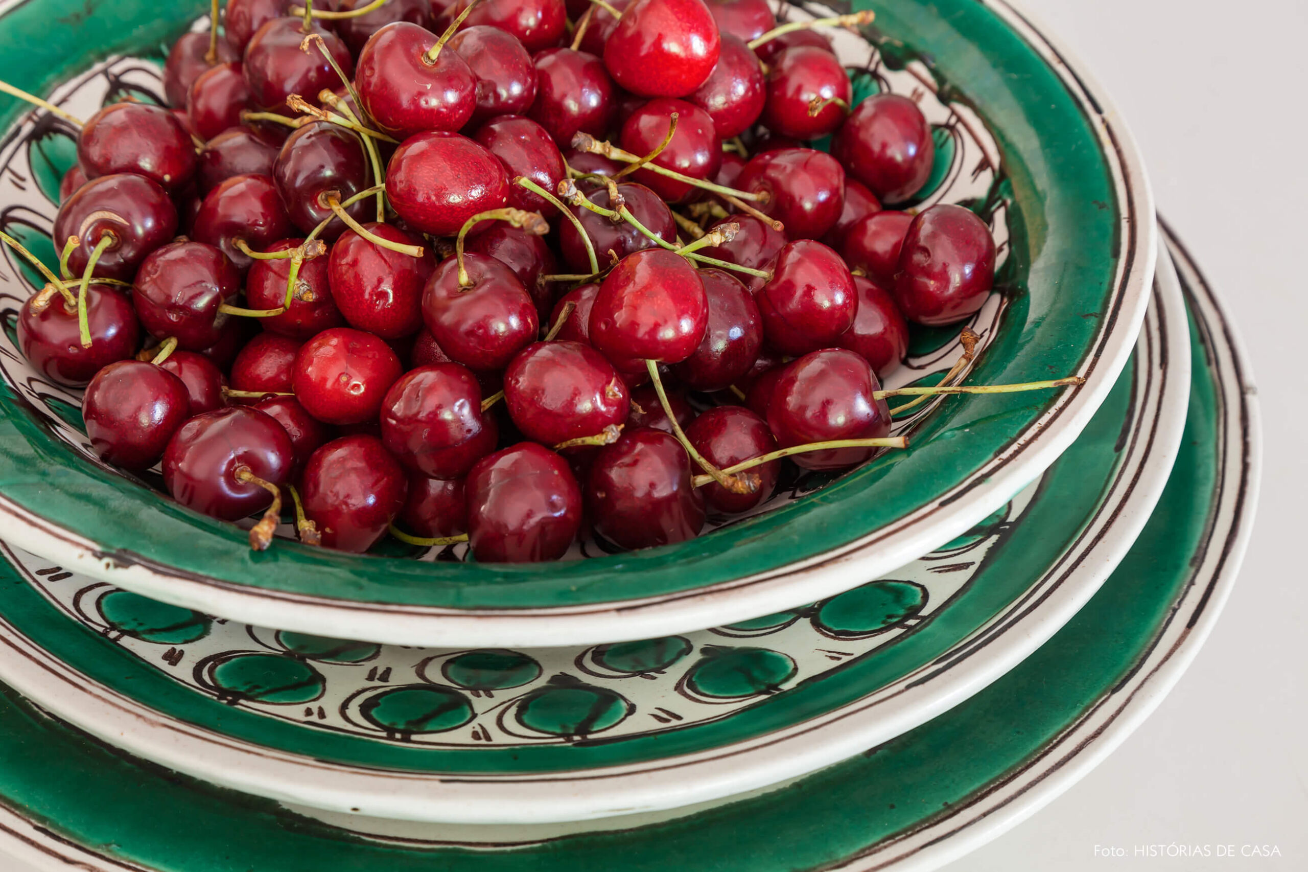 detalhe da decoração de prato verde e cerejas