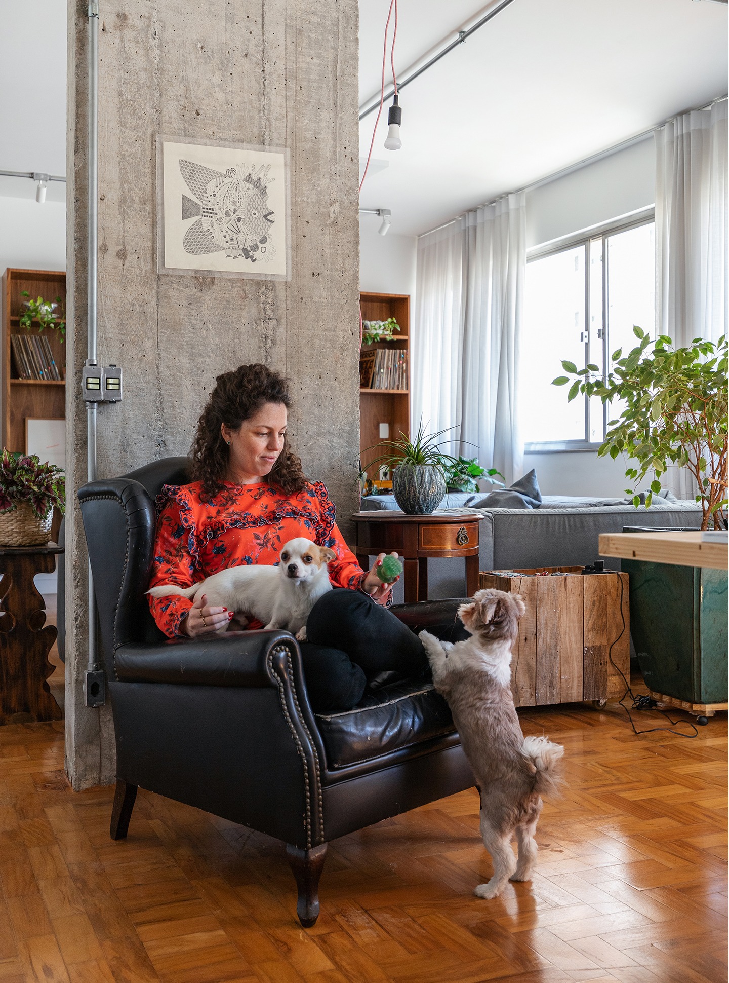 Retrato em sala com piso de madeira e parede de concreto
