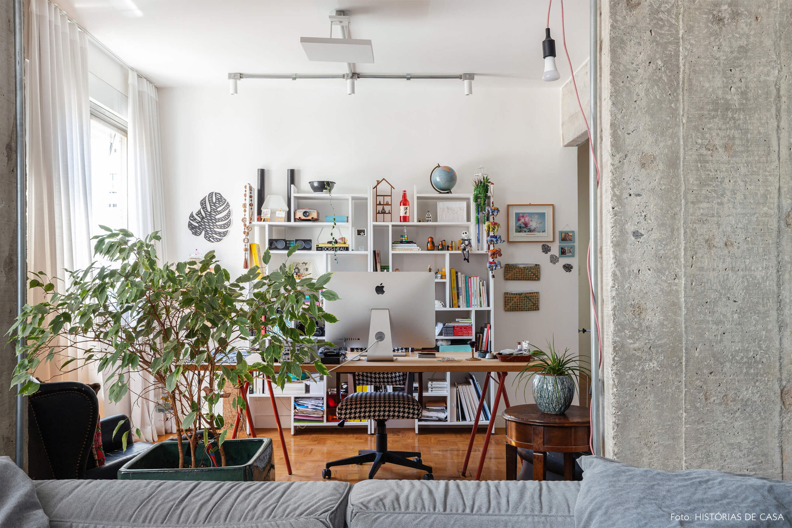 Escritório com parede de concreto e planta