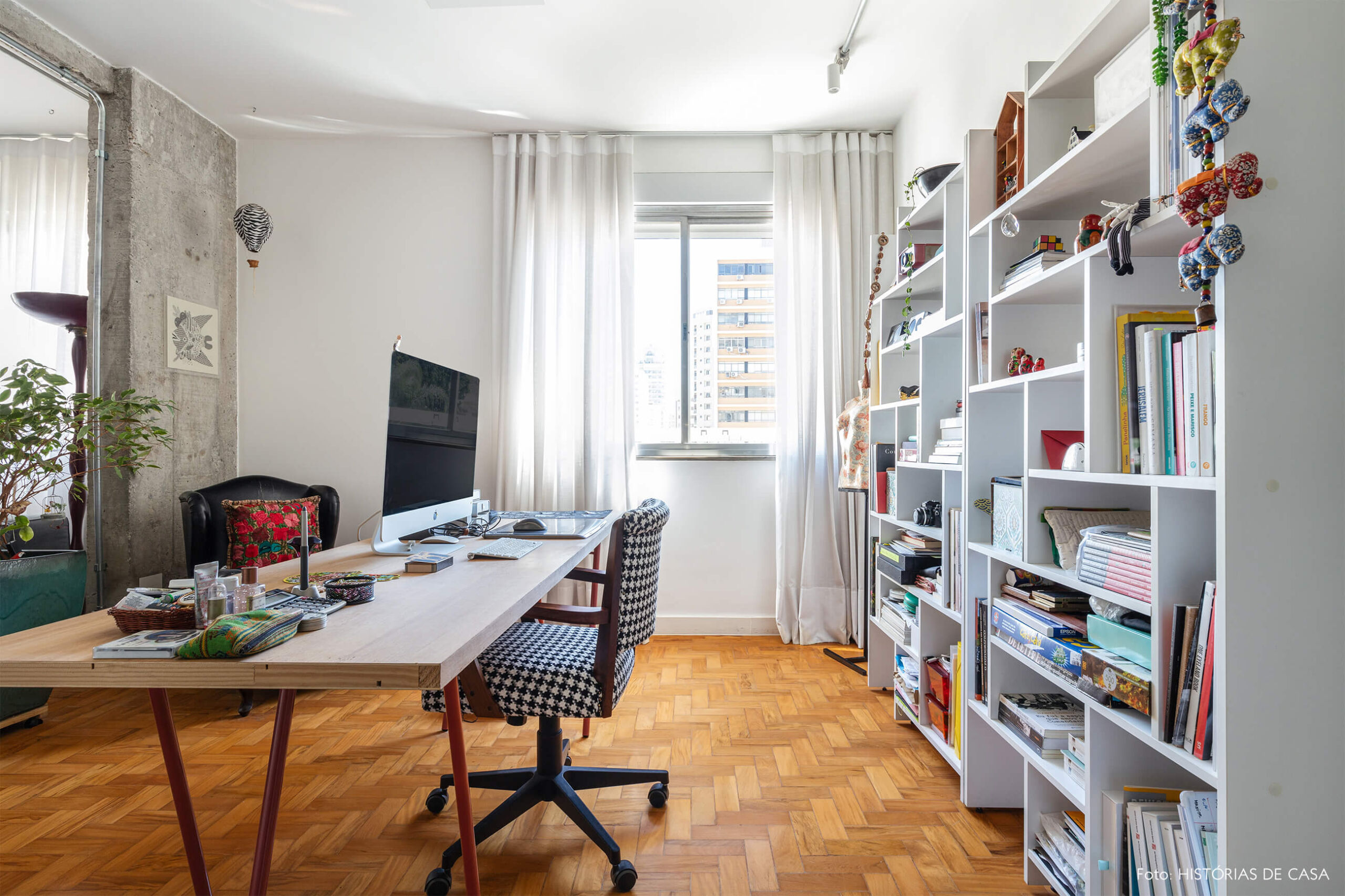 Escritório com piso de madeira e paredes brancas