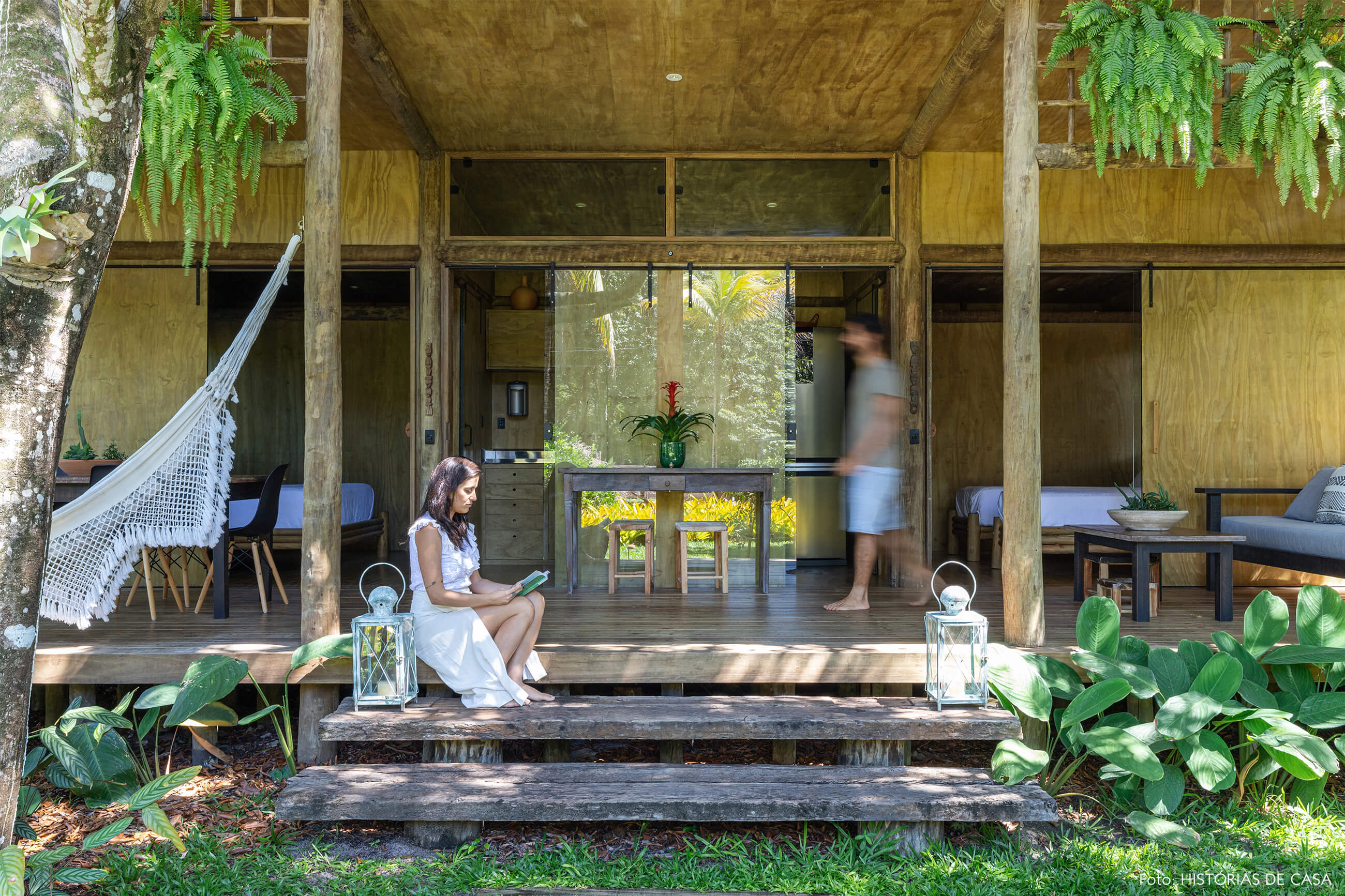 hotel-villase7e-36-retrato-entrada-madeira-rede-cadeira-eames-preta-luminaria-branca-mesa-madeira-escura-banco