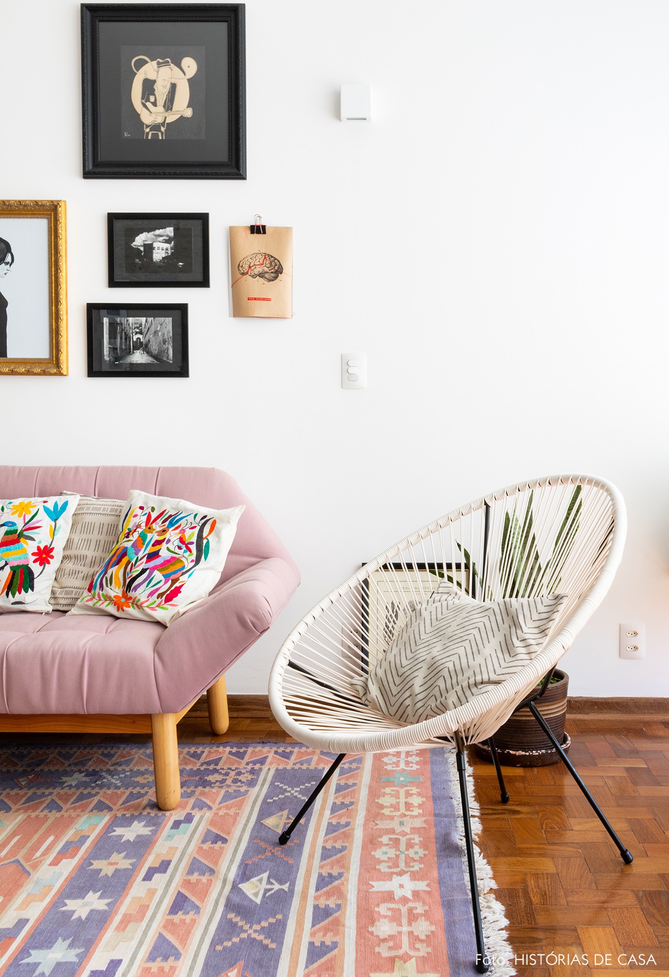 sala-sofa-rosa-cadeira-branca-tapete-estampado-piso-madeira-quadros