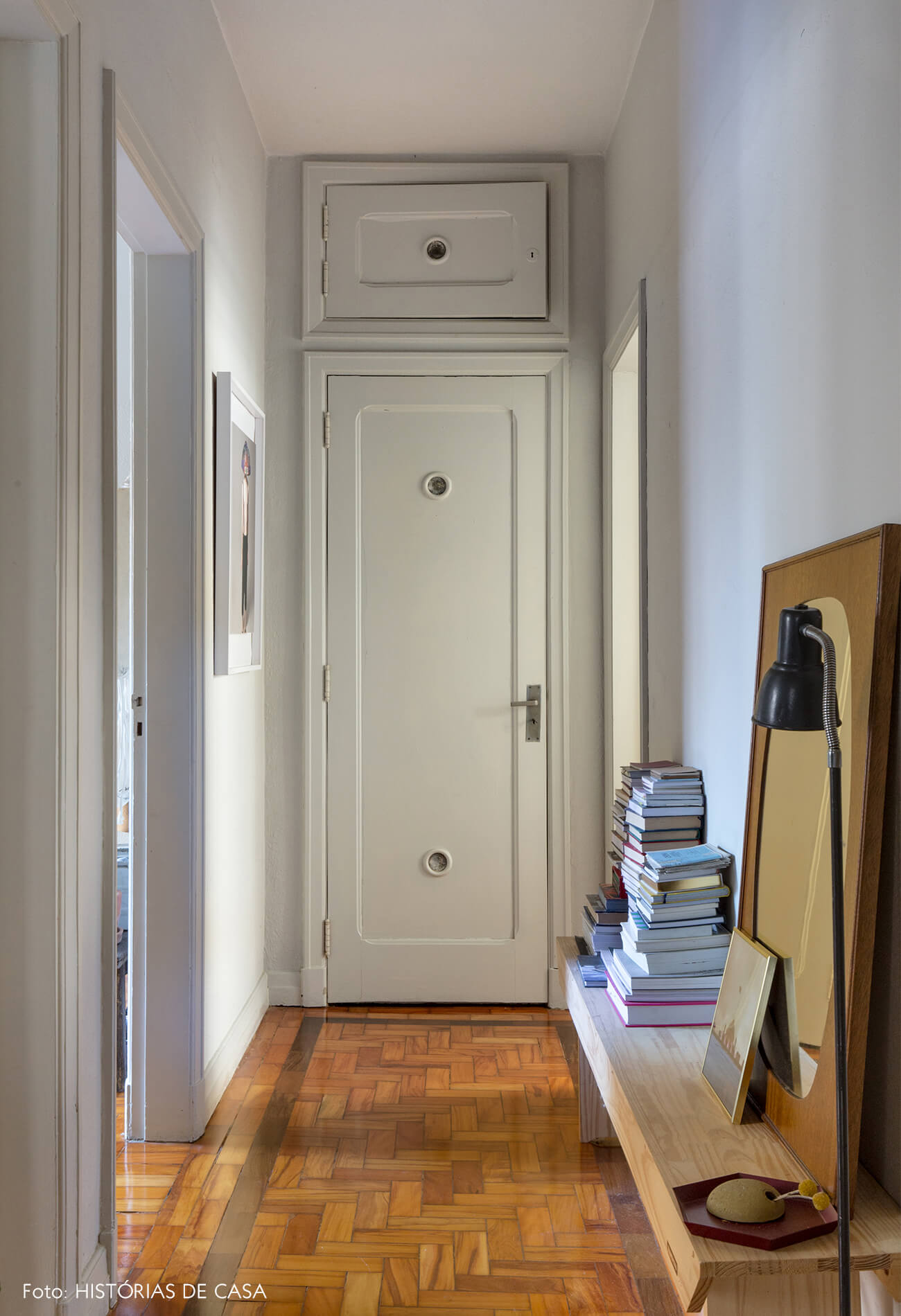 corredor com paredes brancas e piso de madeira