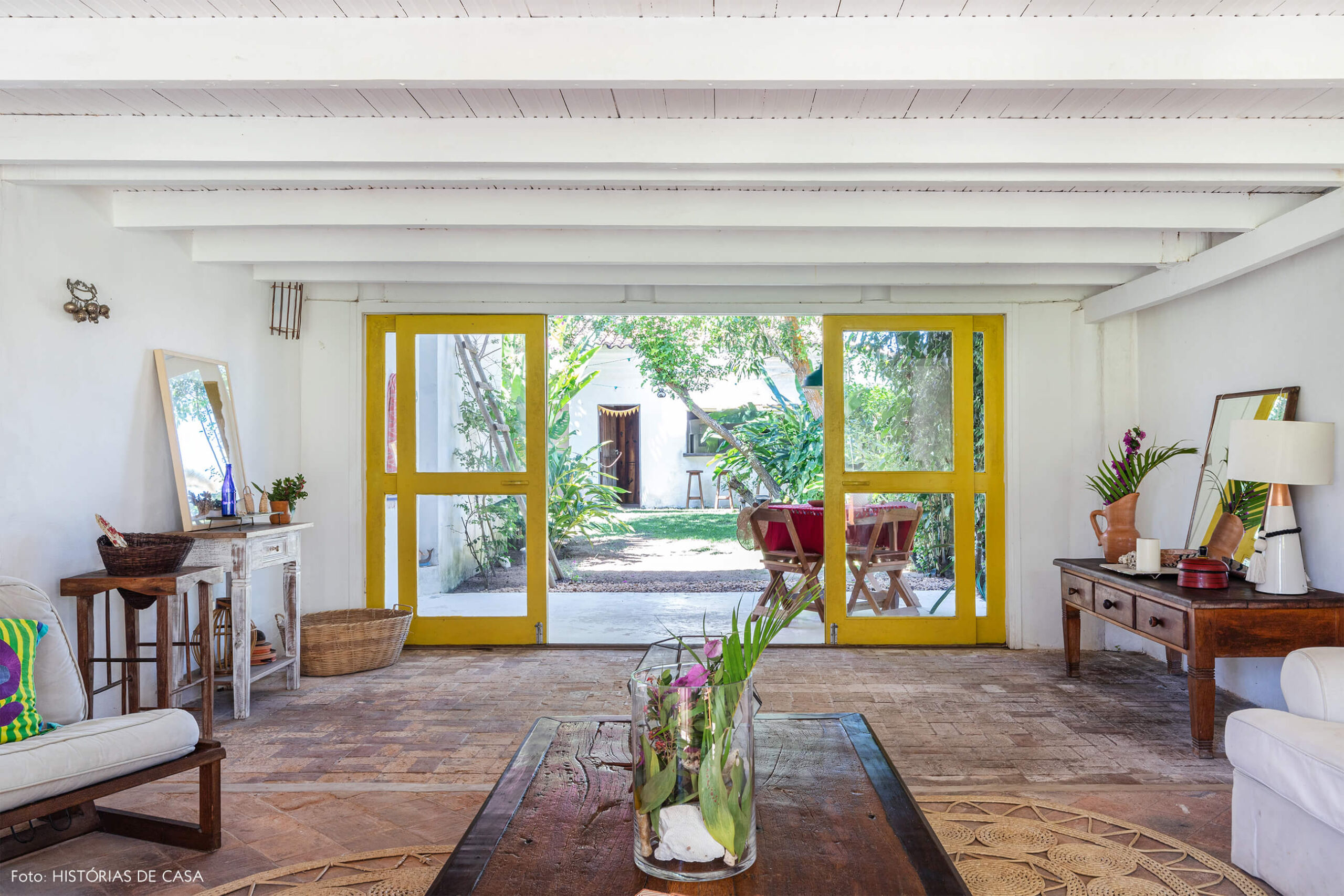 flavia-decoração-trancoso-sala-com-itens-de-madeira-e-varanda-com-pora-amarela