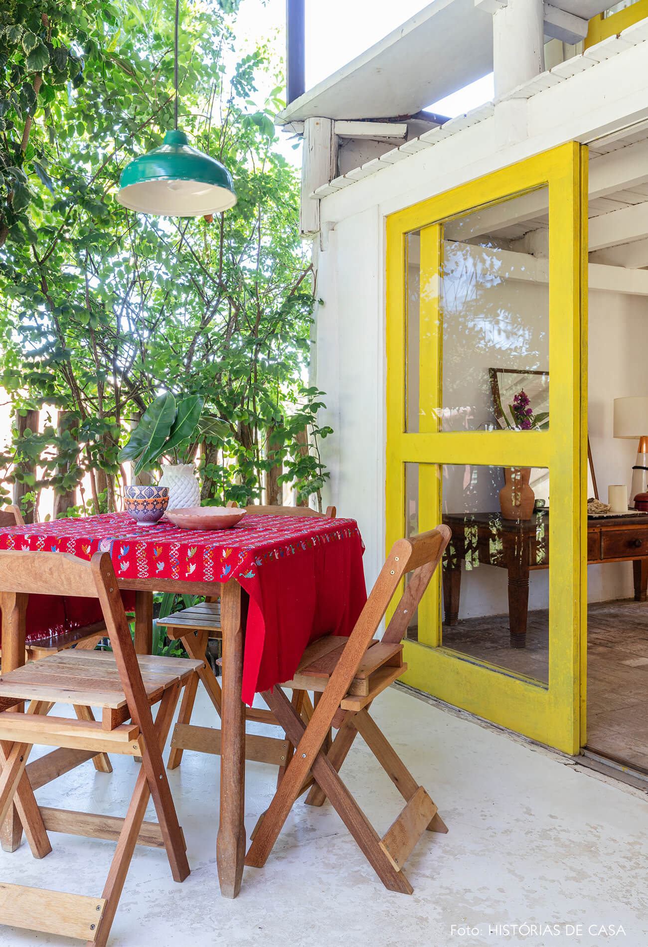 flavia-decoração-trancoso-varanda-com-mesa-de-madeira-e-porta-amarela
