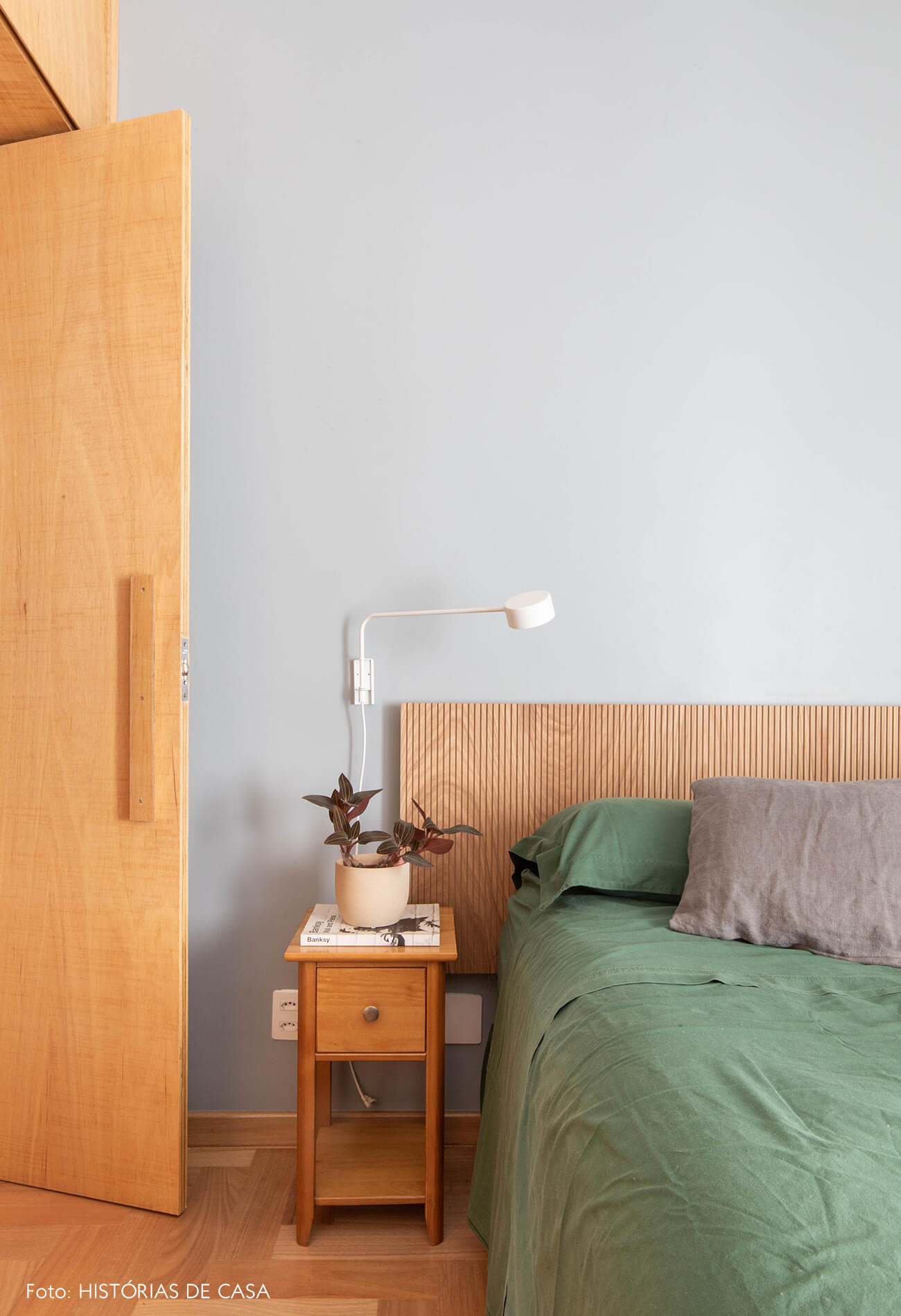 decoração quarto com parede cinza e cabiceira de madeira clara