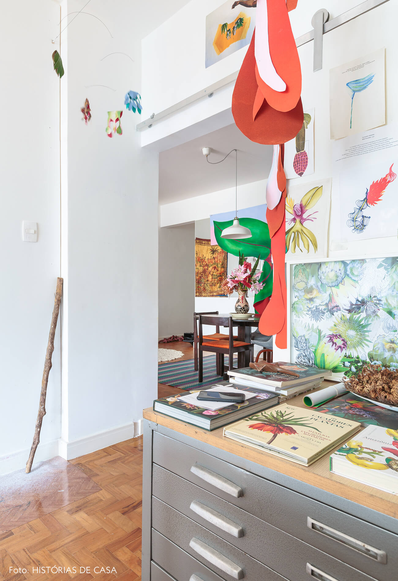 decoração atelie com obras de arte e mobile de flores