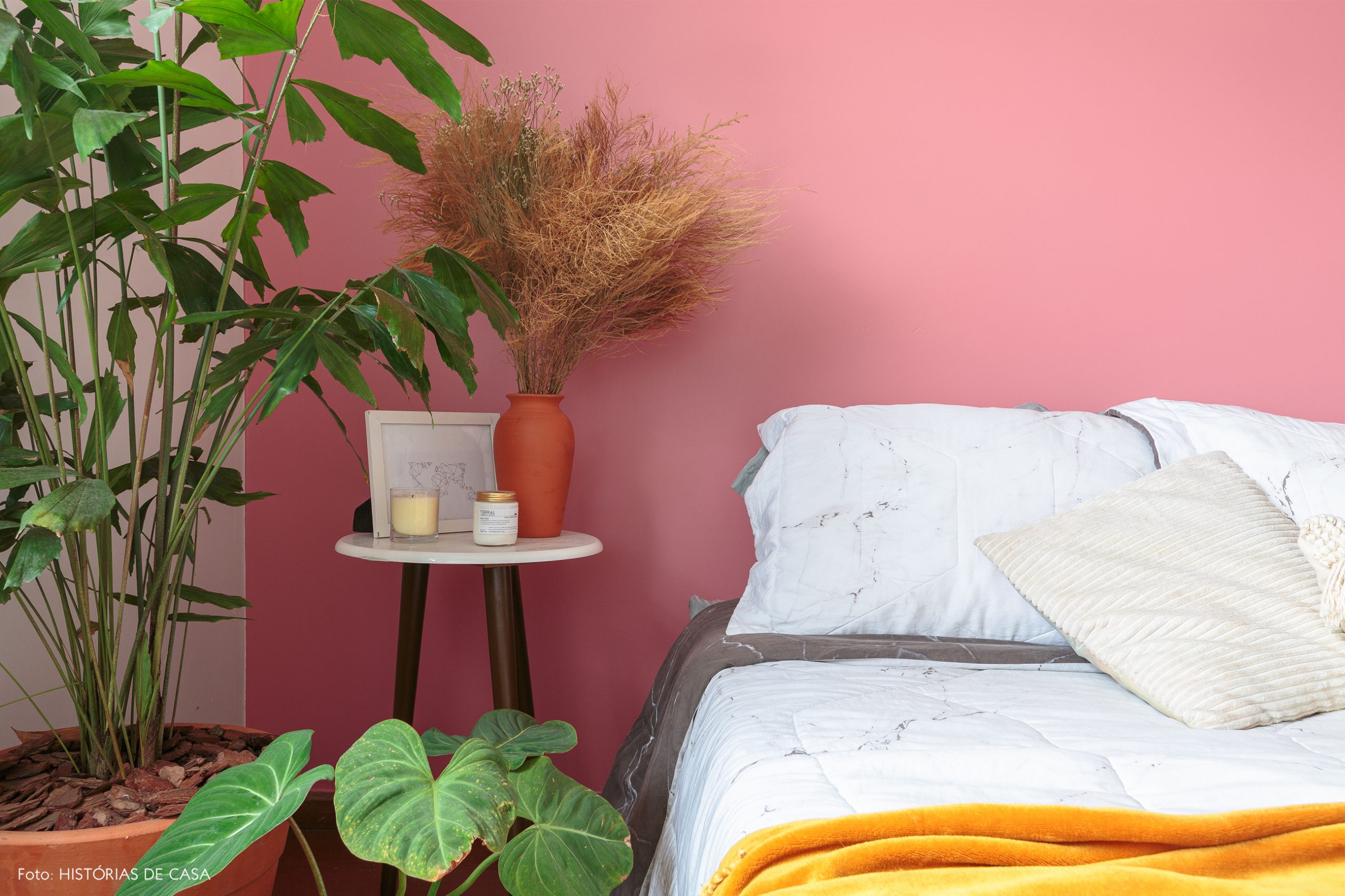 decoração quarto com parede rosa plantas e mesa branca