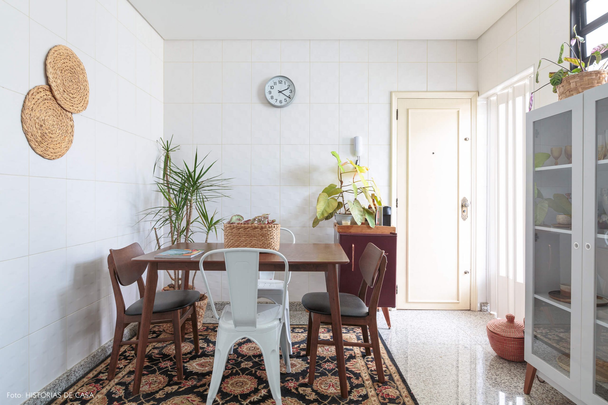 decoração cozinha com mesa de madeira escura, objeots palha e tapete estampado