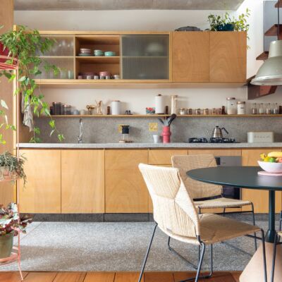 decoração cozinha com armarios de amdeira clara e mesa redonda escura