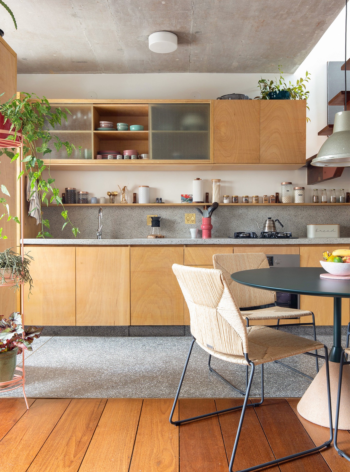 decoração cozinha com armarios de amdeira clara e mesa redonda escura