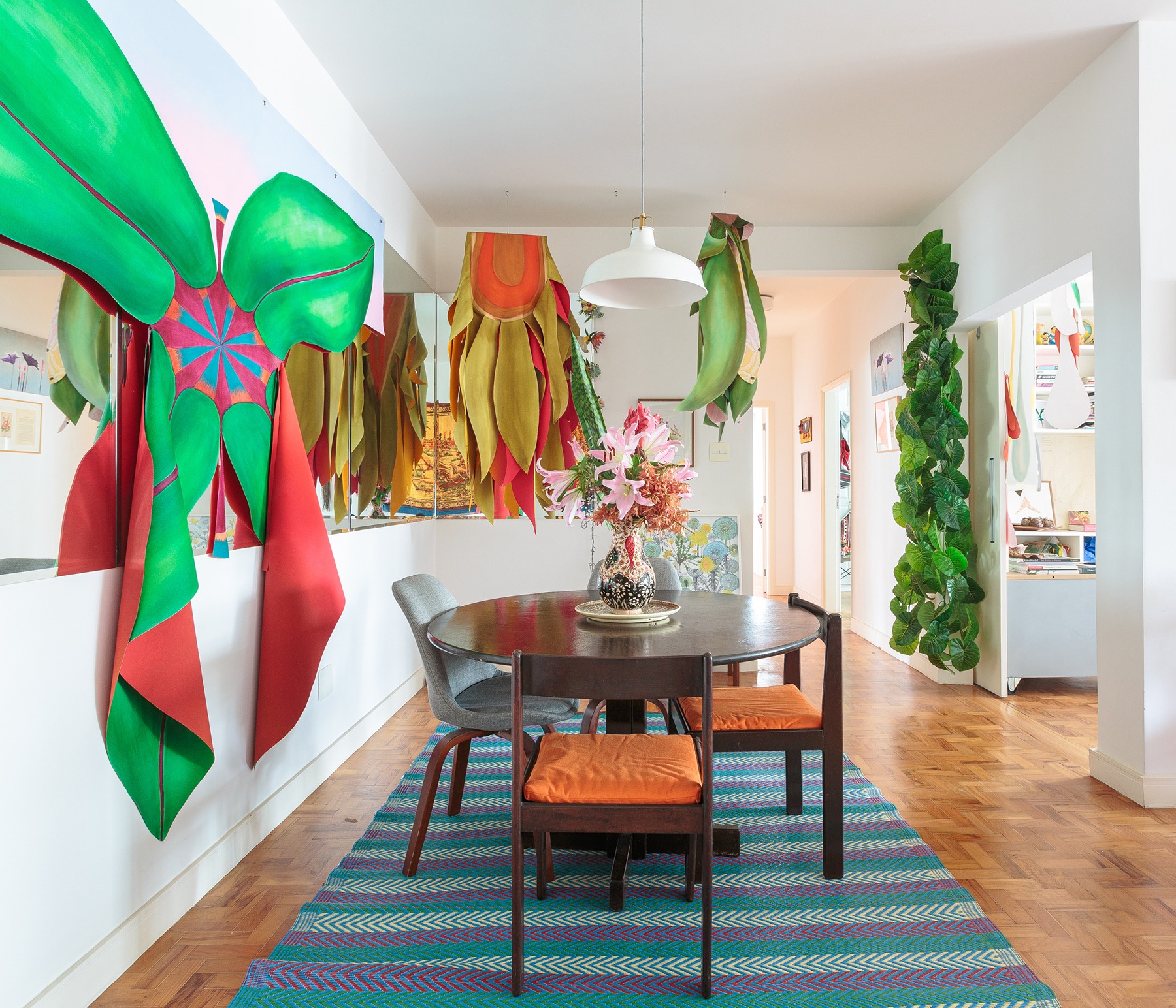 decoração sala jantar colorida com obras de arte na paerede e mesa de madeira