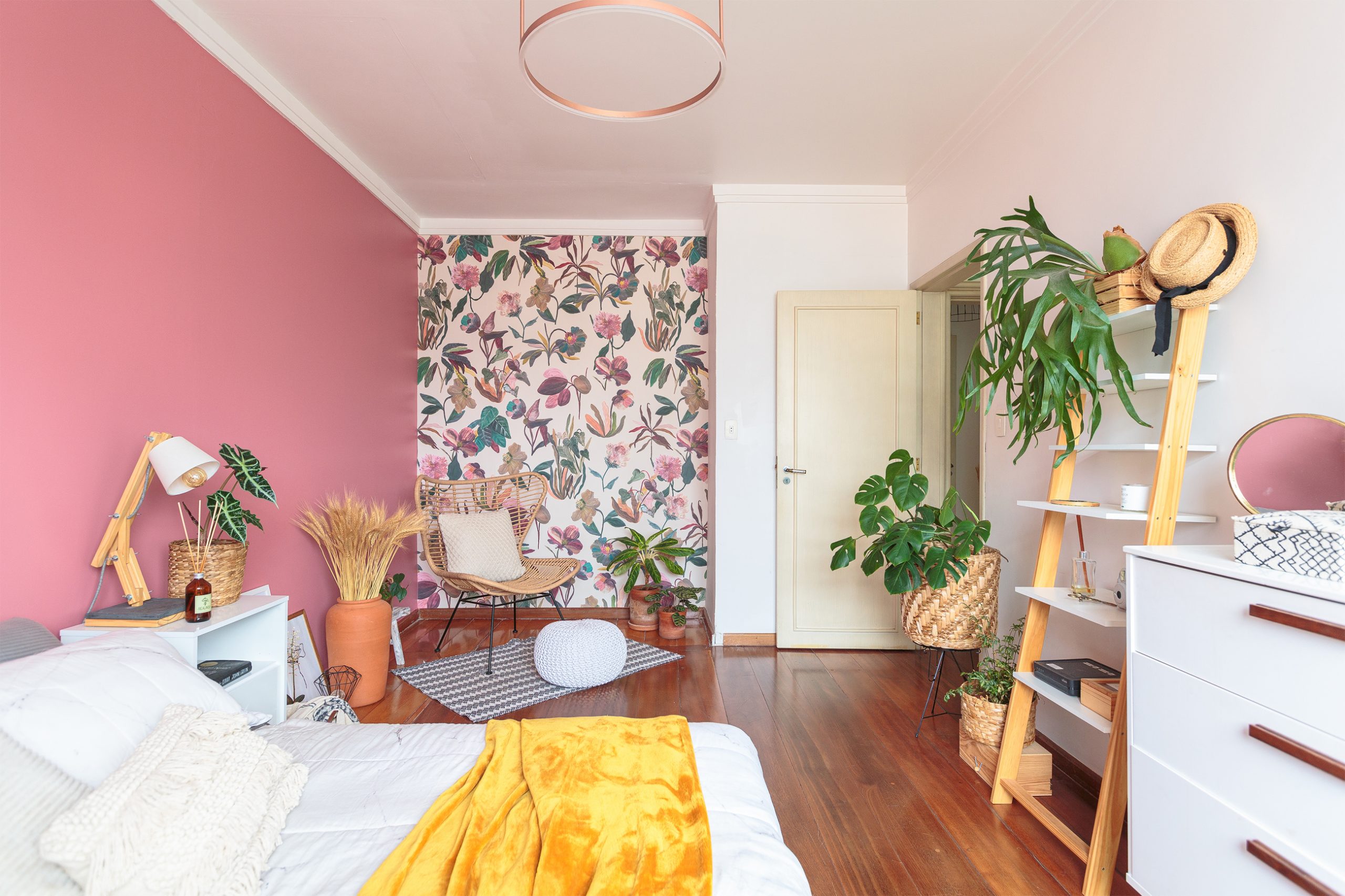 decoração quarto com parede rosa e papel de parede floral cestos e plantas