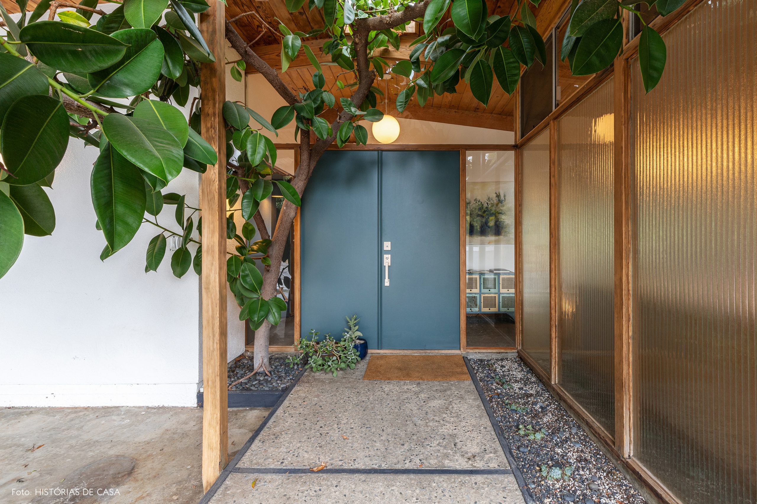 decoração casa de vidro canelado e madeira com porta azul