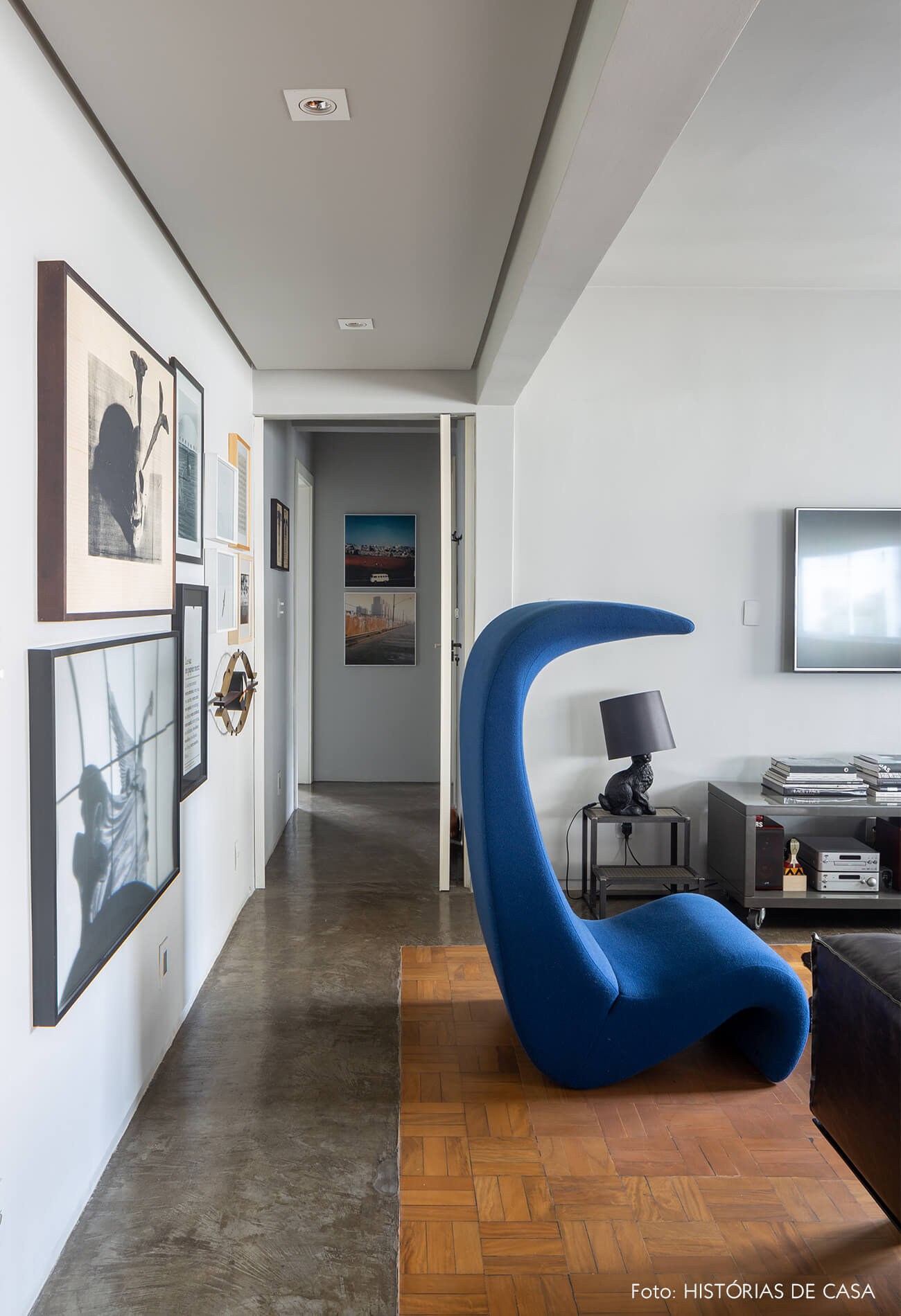 decoração sala tv com poltrona curva azul e abajur cachorro preto