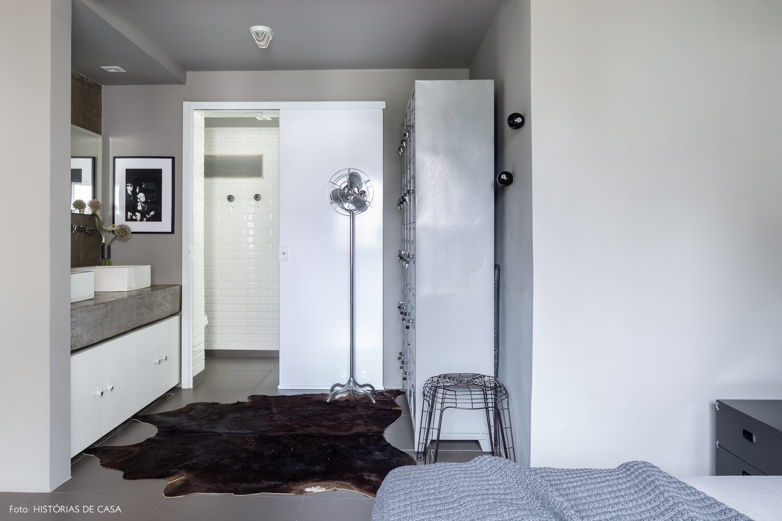 decoração suite com paredes cinzas armario de metal e tapete pele animal