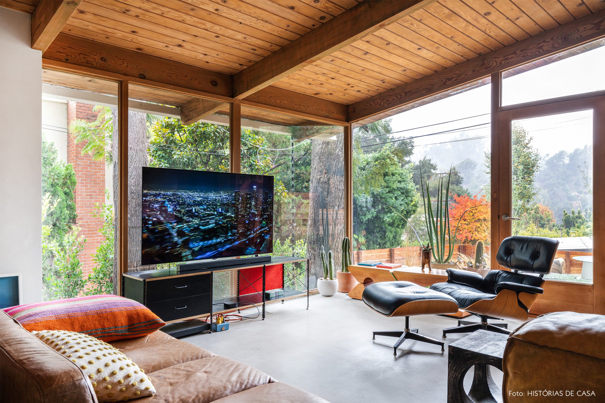 decoração casa de madeira e vidro e sala com sofá e poltrona de couro