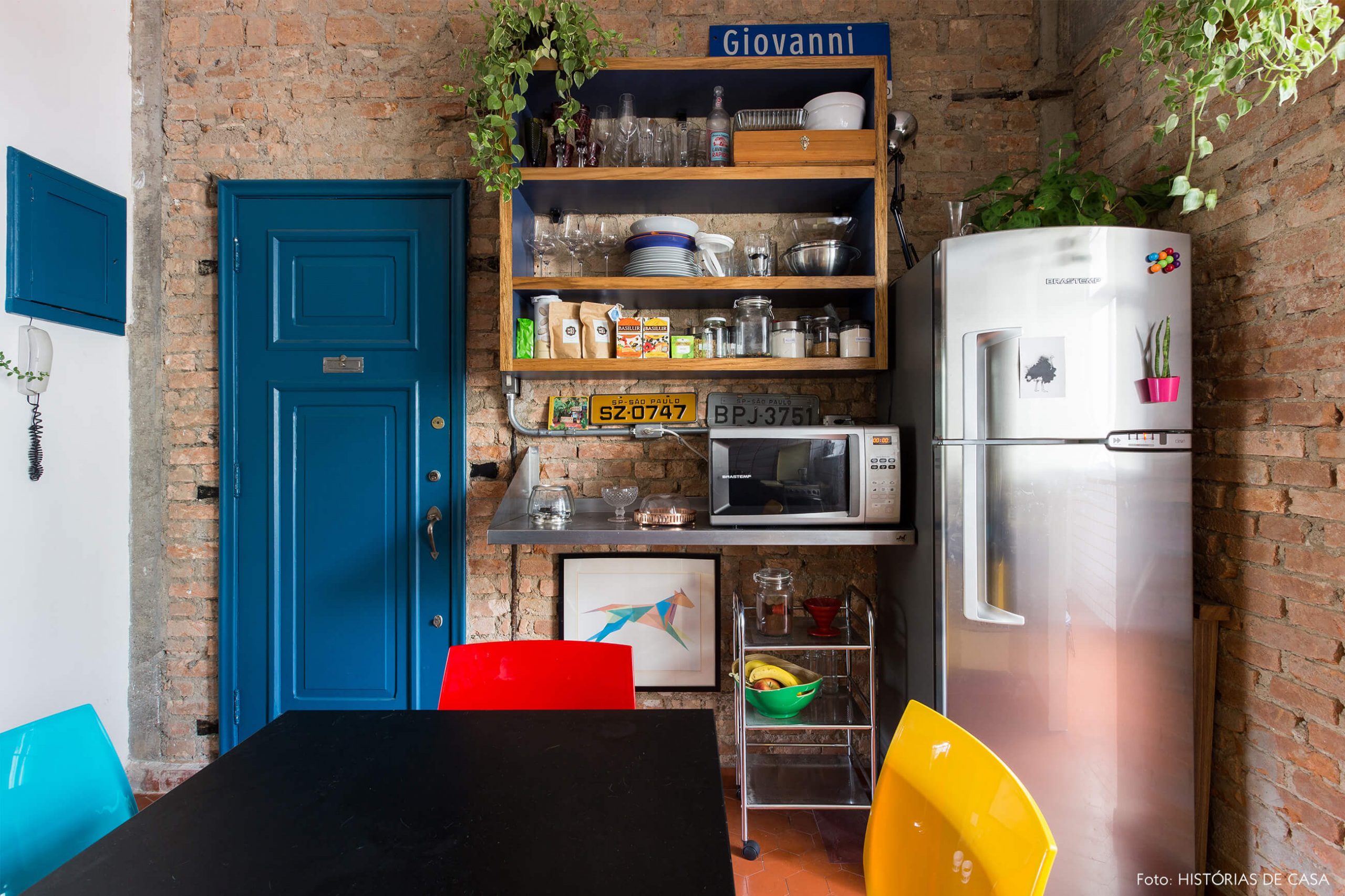 decoração cozinha com parede de tijolos e porta azul