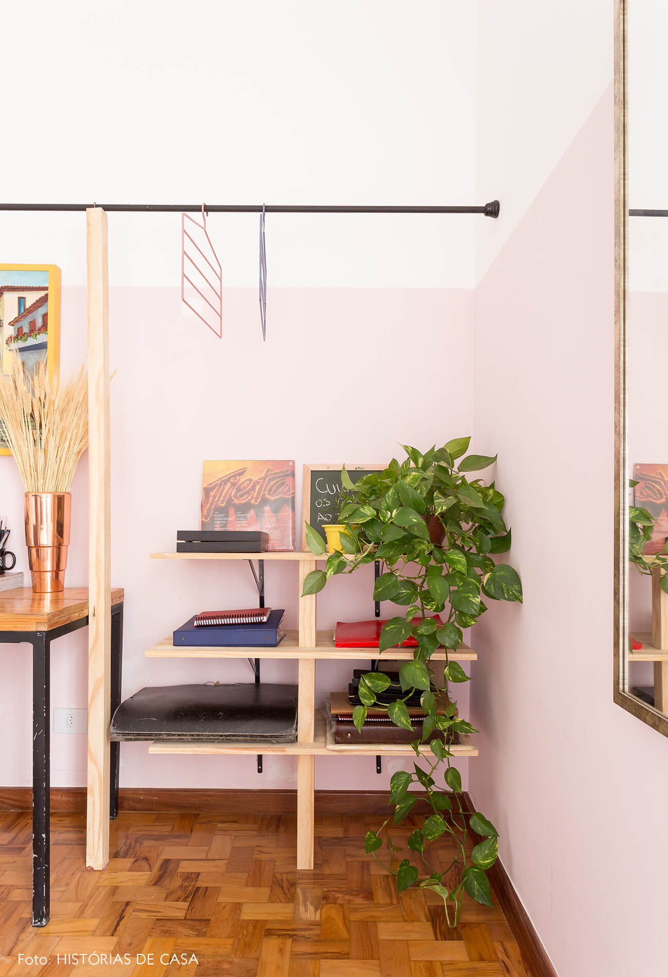 decoração quarto com meia parede rosa prateleiras de madeira clara e arara de ferro